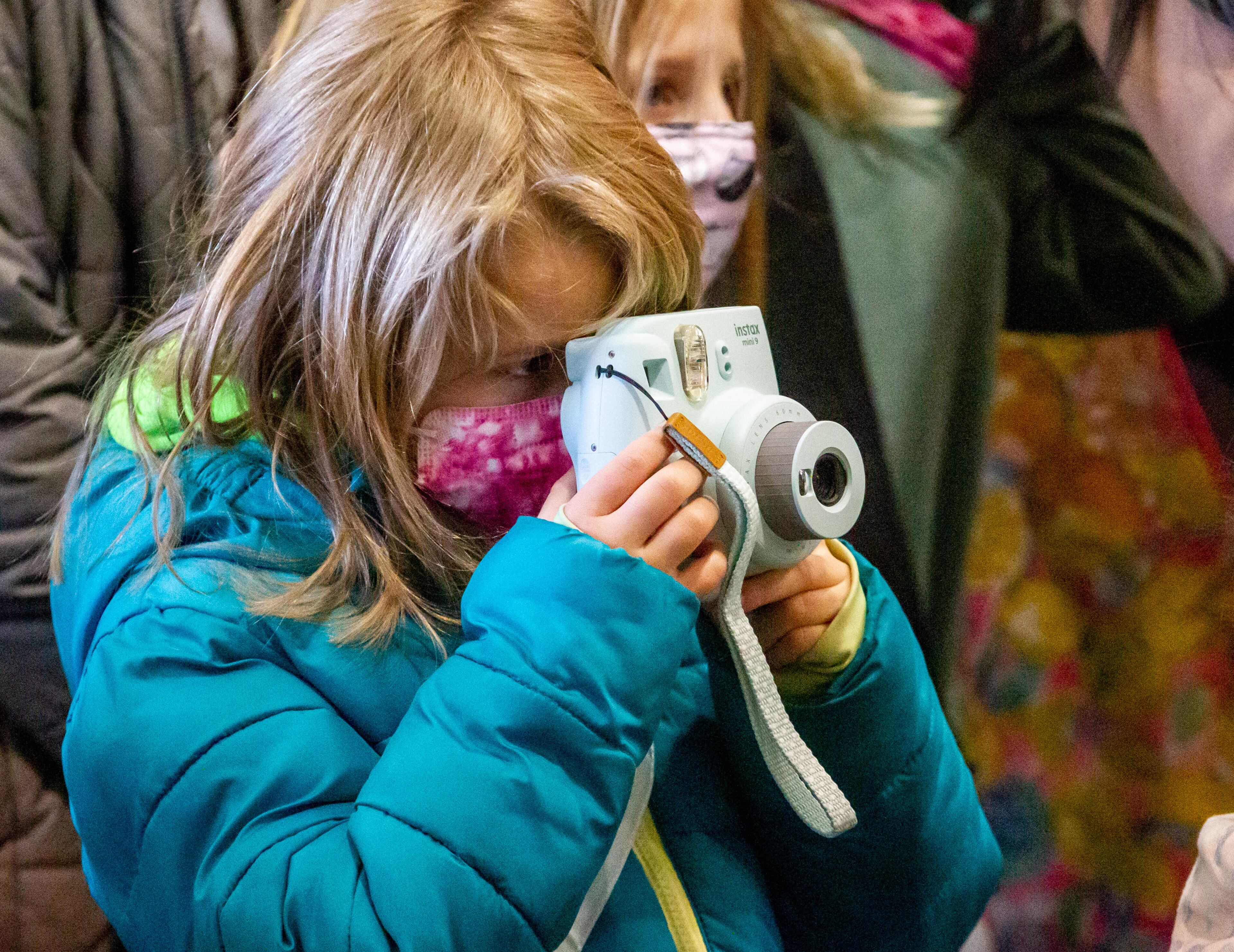 A young girl takes photographs of the Lion Dance performers during Decatur's first Lunar New Year celebration at Legacy Park on Saturday, January 29, 2022. STEVE SCHAEFER FOR THE ATLANTA JOURNAL-CONSTITUTION