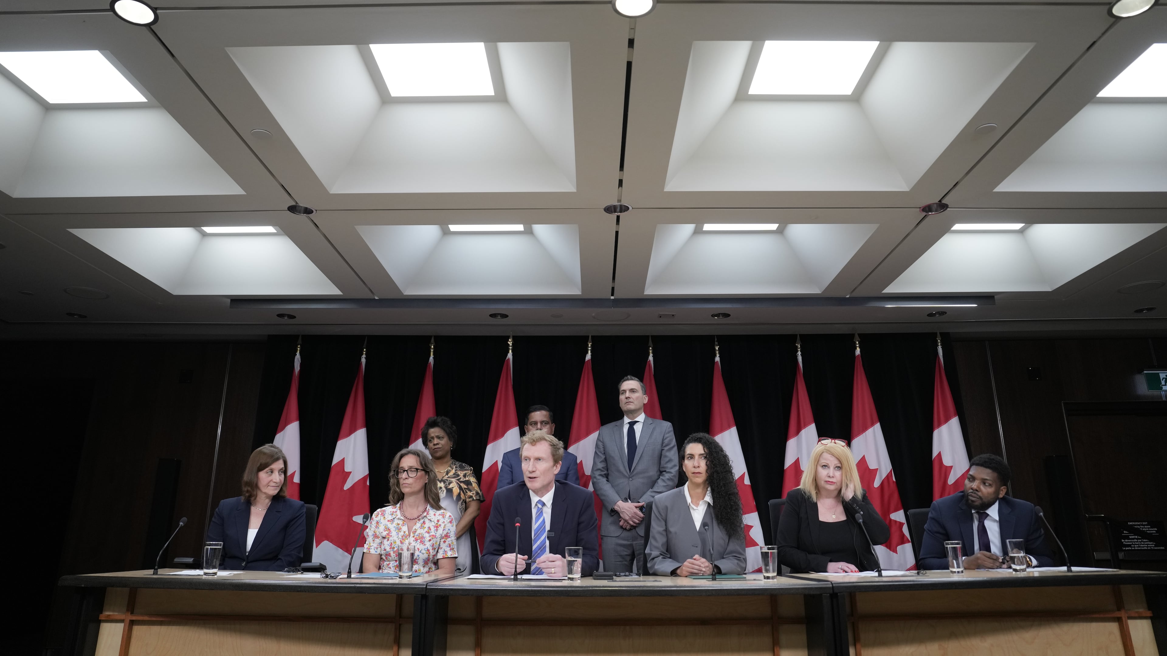 Canadian Identity and Culture Minister Marc Miller speaks as colleagues and medical professionals look on during a news conference in Ottawa, Ontario, Wednesday, June 10, 2026. (Adrian Wyld/The Canadian Press via AP)