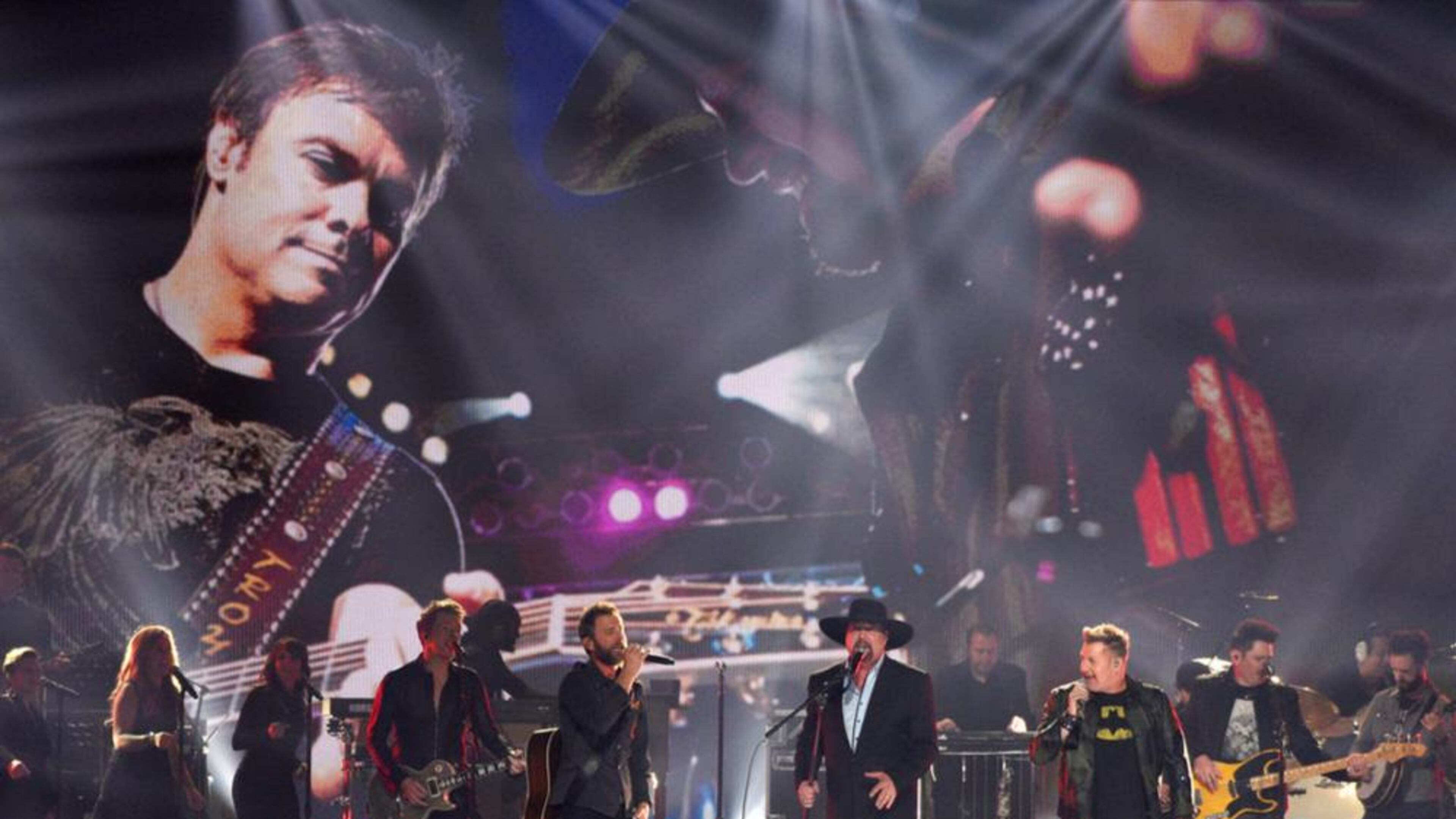 Joe Don Rooney,from left, Dierks Bentley,Eddie Montgomery,Gary LeVox, and Jay DeMarcus perform "My Town"during a tribute to Troy Gentry at the 51st annual CMA Awards at the Bridgestone Arena on Wednesday, Nov. 8, 2017, in Nashville, Tenn.
