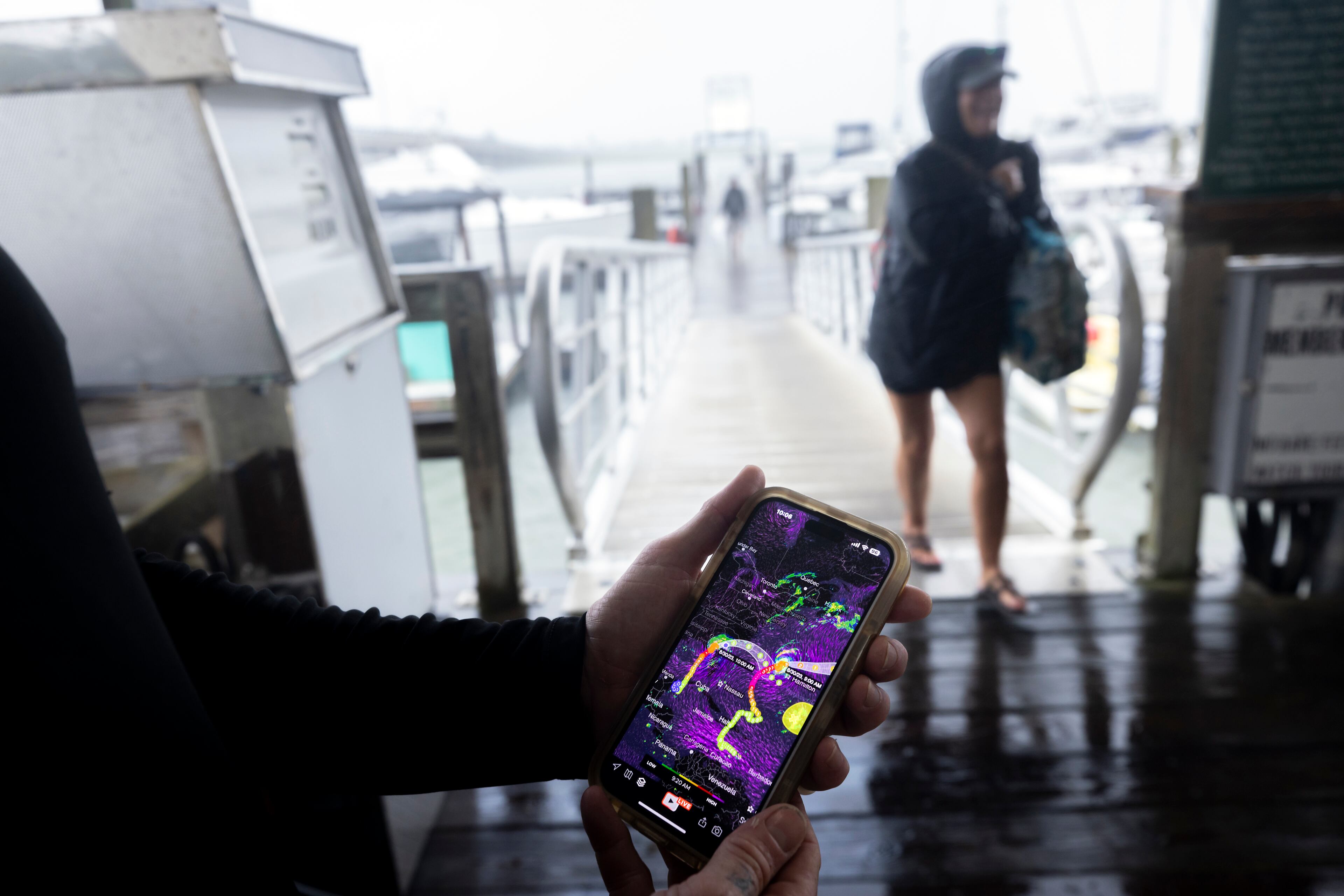 Brandon Long, left, owner of Bull River Marina, checks an app on his phone for the latest tracks of Hurricane Idalia and Franklin as one of his boat owners leaves the marina Wednesday in Savannah. Hurricane Idalia hit the gulf coast of Florida as a Category 3 storm and is expected to bring wind and rain.