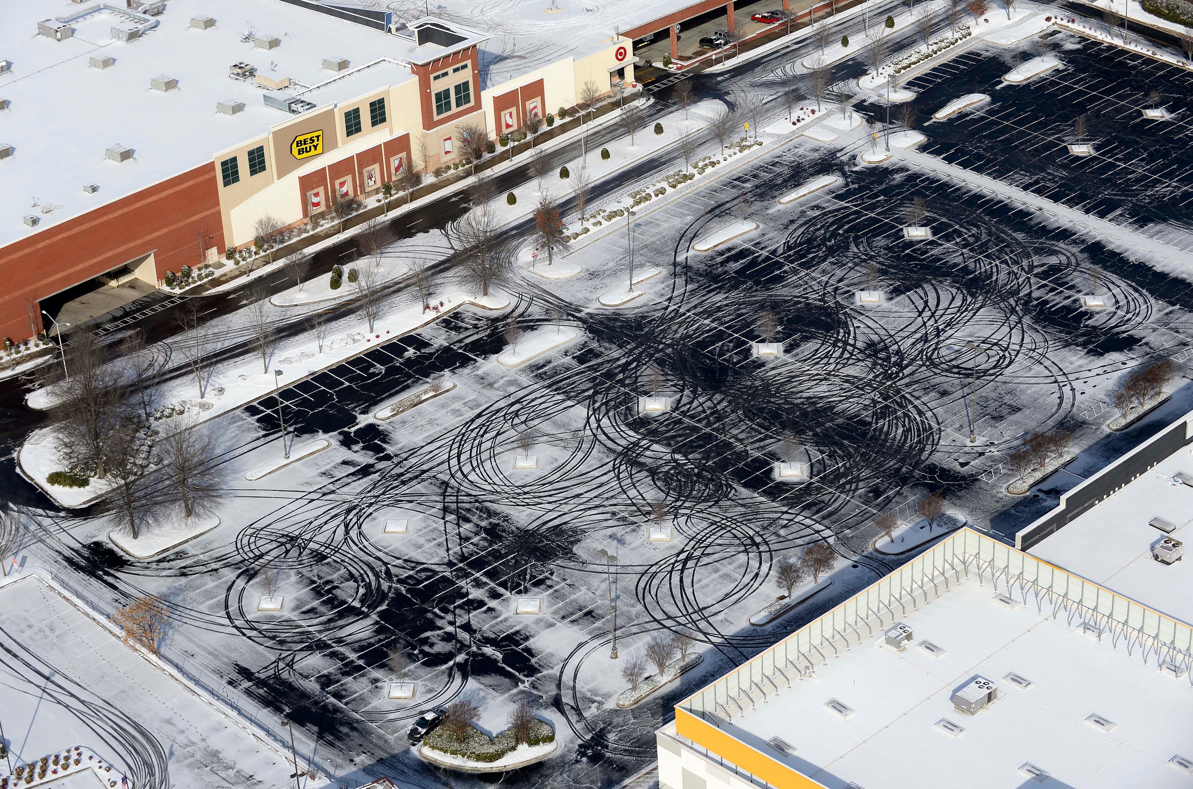 This aerial view, an electronics store parking lot shows the effects of a winter snow storm Wednesday, Jan. 29, 2014, in Atlanta.