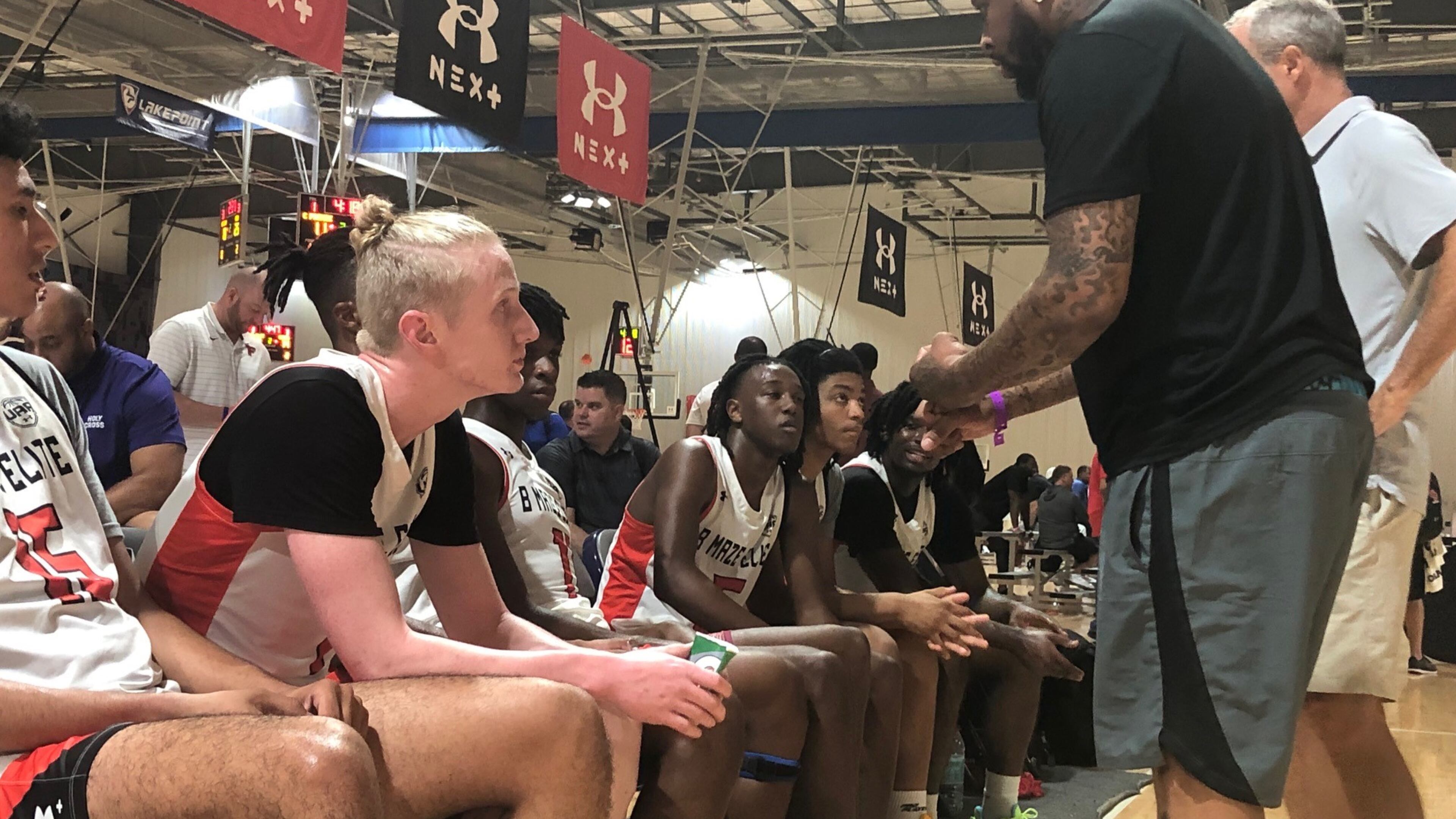 Blue Cain (black t-shirt, foreground) listens to the instruction of B. Maze Elite coach Bobby Maze during a break in action of the team's AAU game vs. the Middlesex Magic July 7, 2022 at the LakePoint Sports gymnasium in Cartersville. Cain announced his commitment to Georgia Tech on June 9, 2022. (AJC photo by Ken Sugiura)