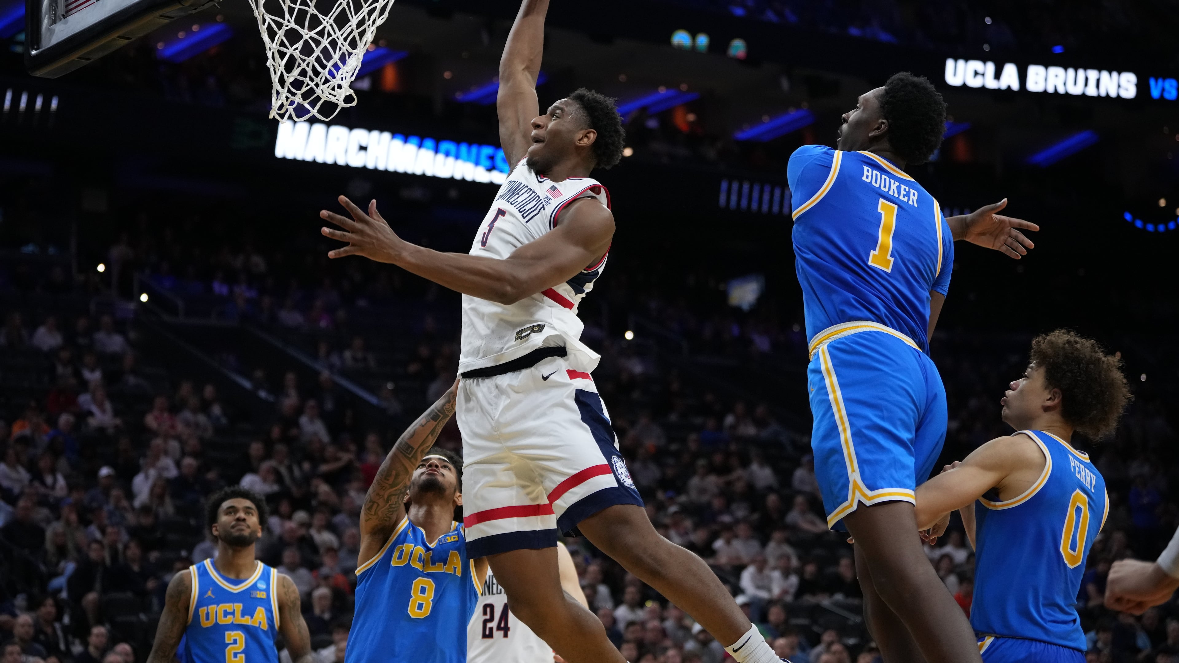 UConn's Tarris Reed Jr. (5) goes up for a dunk [ast UCLA's Xavier Booker (1) and Eric Freeny (8) during the second half in the second round of the NCAA college basketball tournament, Sunday, March 22, 2026, in Philadelphia. (AP Photo/Matt Slocum)