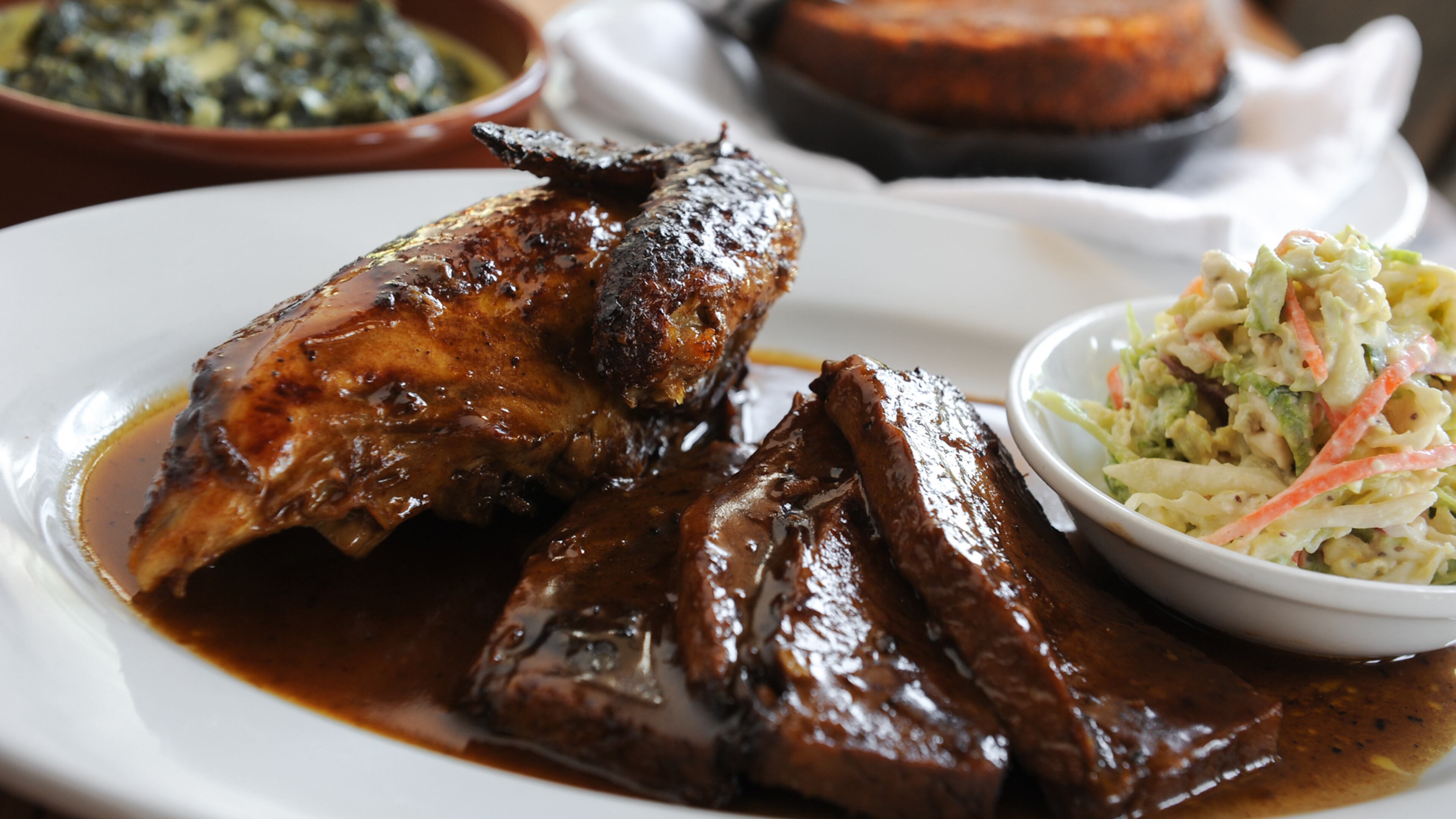 Combo plate of smoked Peruvian style sliced beef brisket and 1/2 Springer Mountain Chicken, served with creamy blue cheese slaw, crackling cornbread and choice of side- Creamed Braising Greens, parmesan béchamel and fennel. (Becky Stein Photography.com)