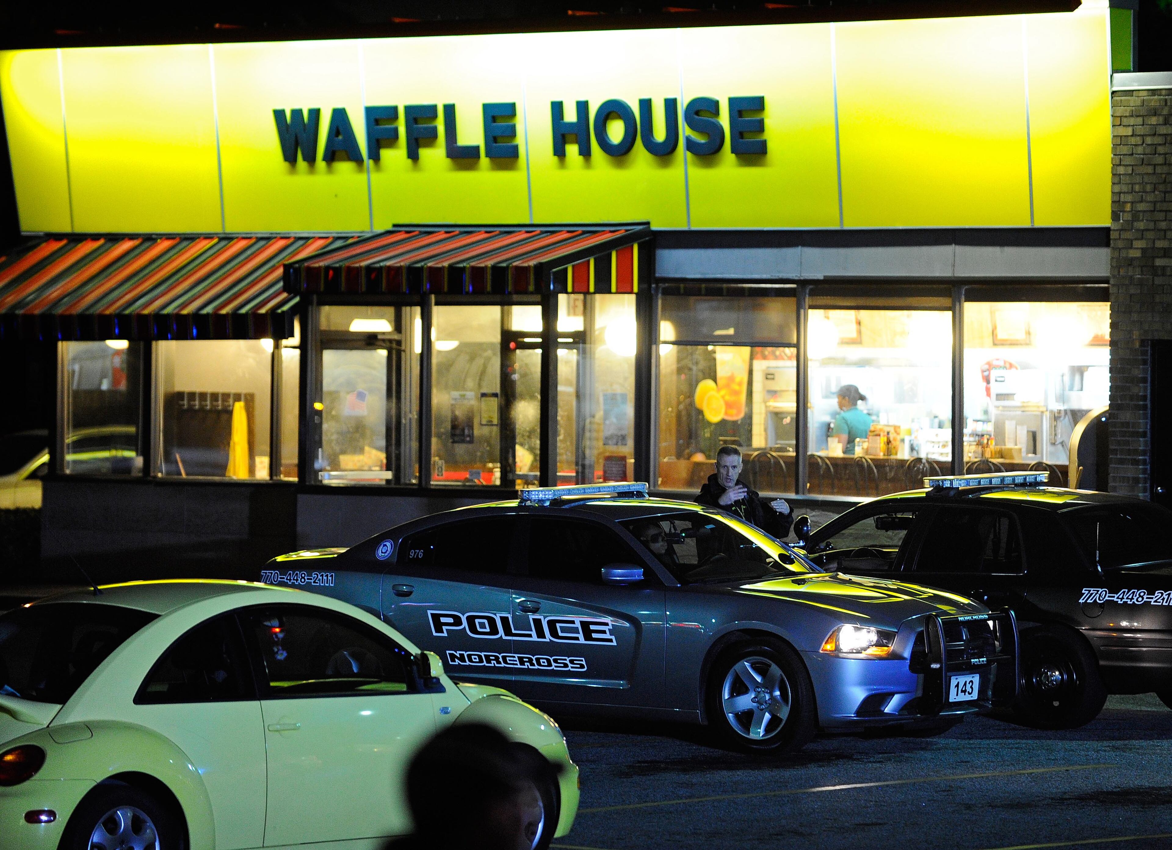 Norcross police and the GBI investigate an officer-involved shooting at the Fusion Event Hall parking lot next to a Knights Inn motel and the adjacent Waffle House at Indian Trail Road and Brook Hollow Parkway on Monday, Oct. 13, 2014, in Norcross, Ga.