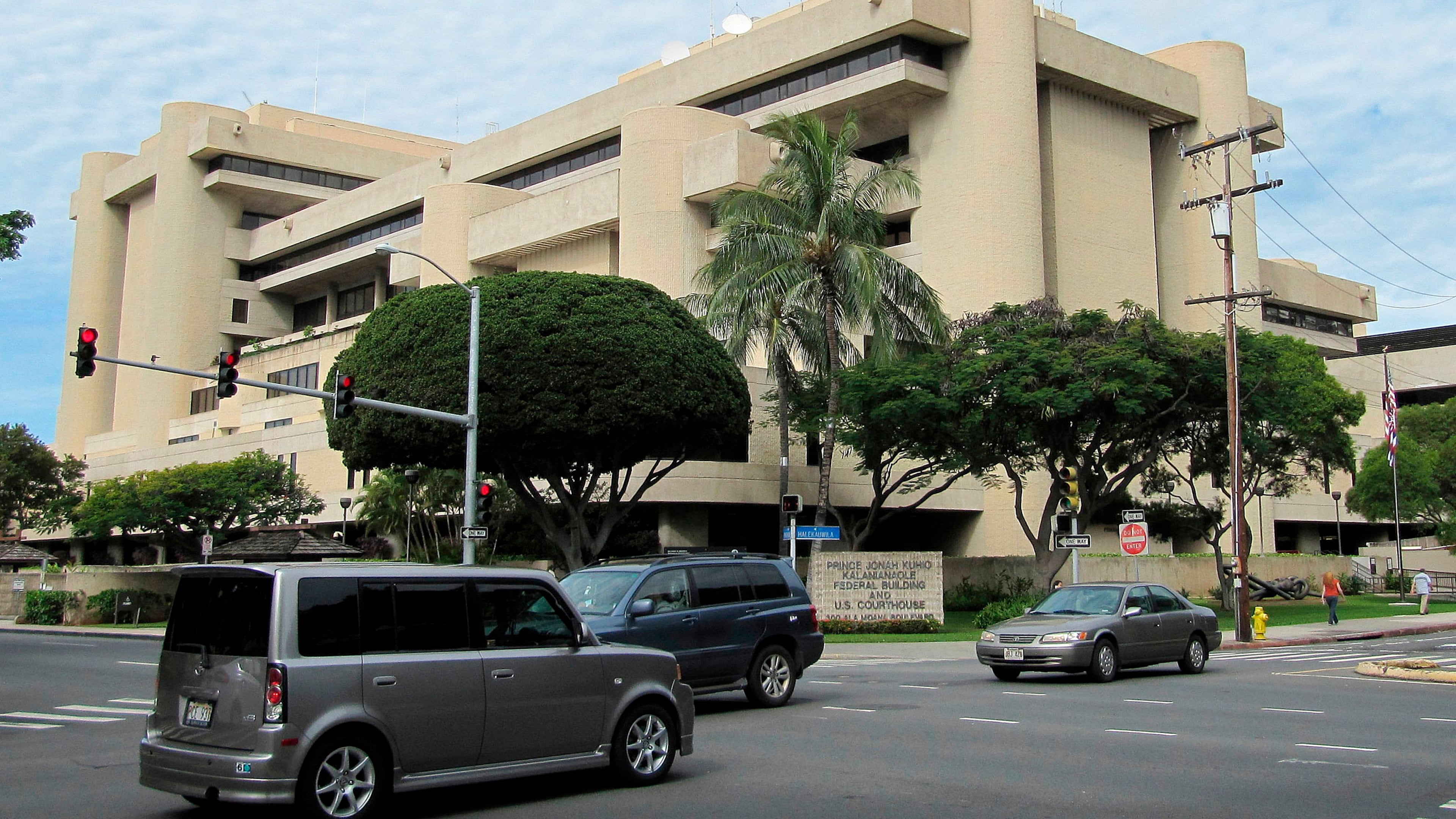 FILE - Cars pass in front of the federal building housing the U.S. District Court in Honolulu on March 7, 2014. (AP Photo/Jennifer Sinco Kelleher, File)