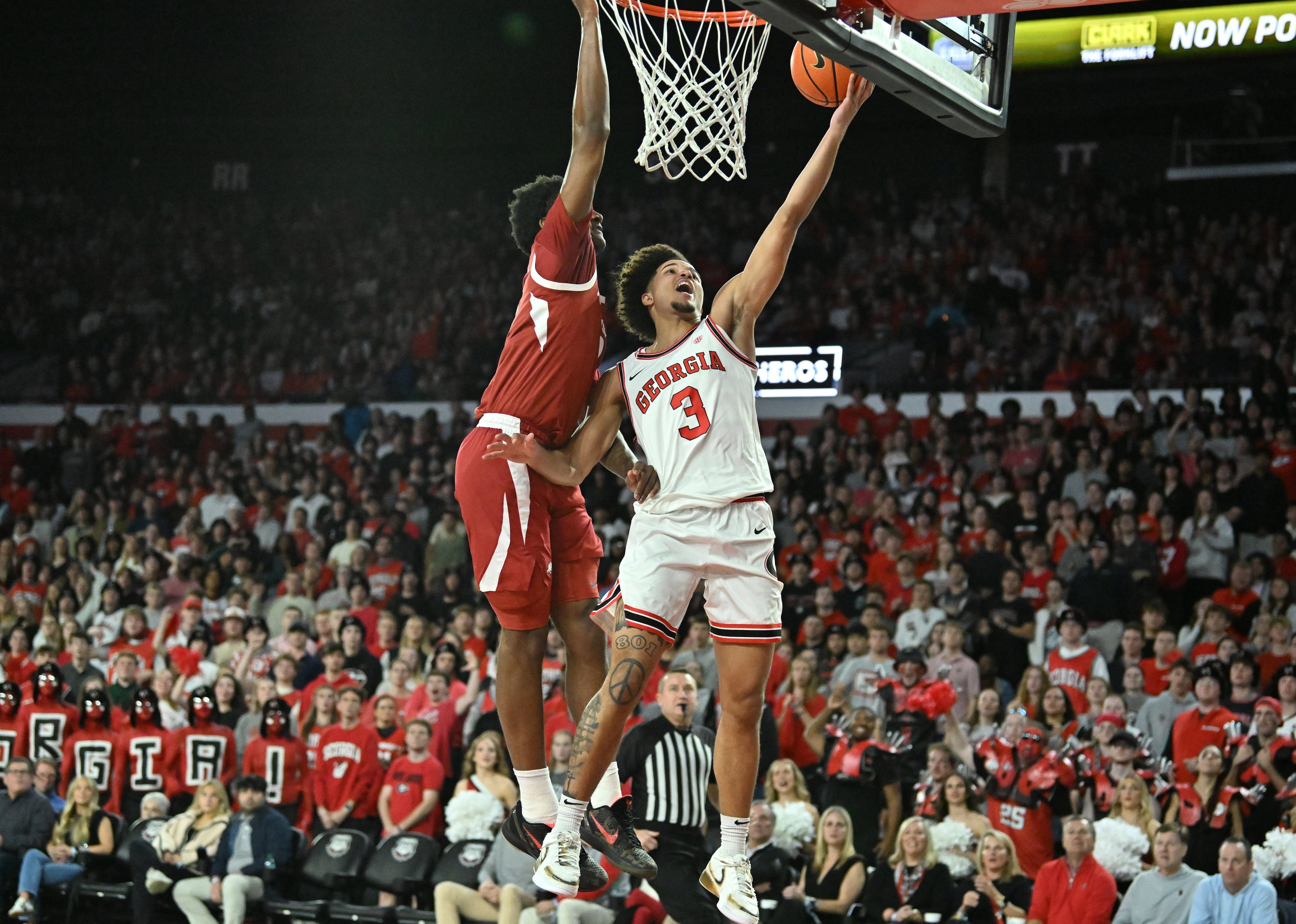 Georgia guard Jordan Ross (right) goes to the basket to shoot against Arkansas forward Karter Knox (left) during the first half in an NCAA college basketball game at Stegeman Coliseum, Saturday, Jan. 17, 2026, in Athens. (Hyosub Shin/AJC)