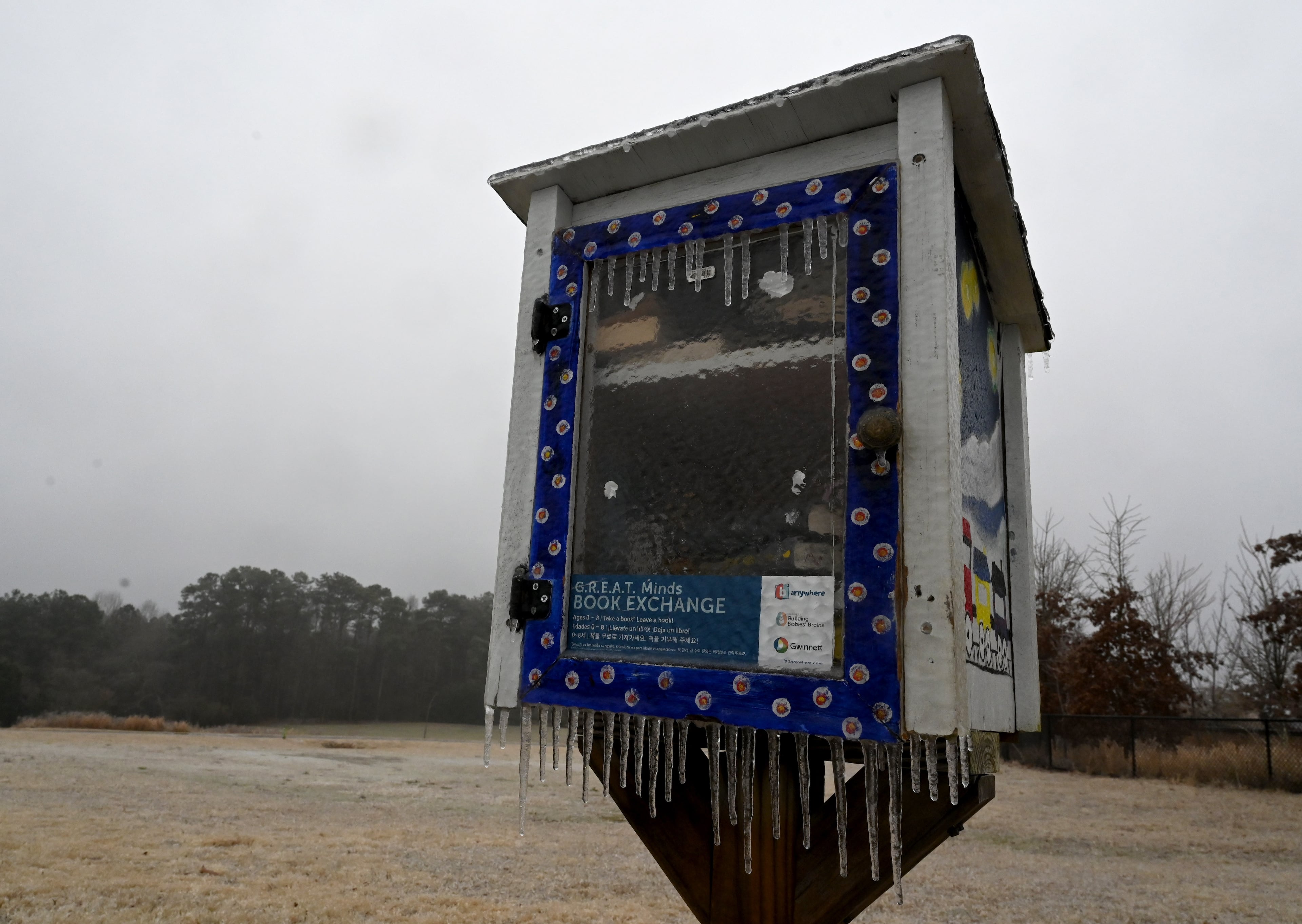 Ice coats a free library book box at Alexander Park, Sunday, Jan. 25, 2026, in Lawrenceville. A wintry mix is slowly making its way across the region Sunday morning. Light rain and sleet were falling at sunrise, creating reports of poor driving conditions due to the ice. (Hyosub Shin/AJC)