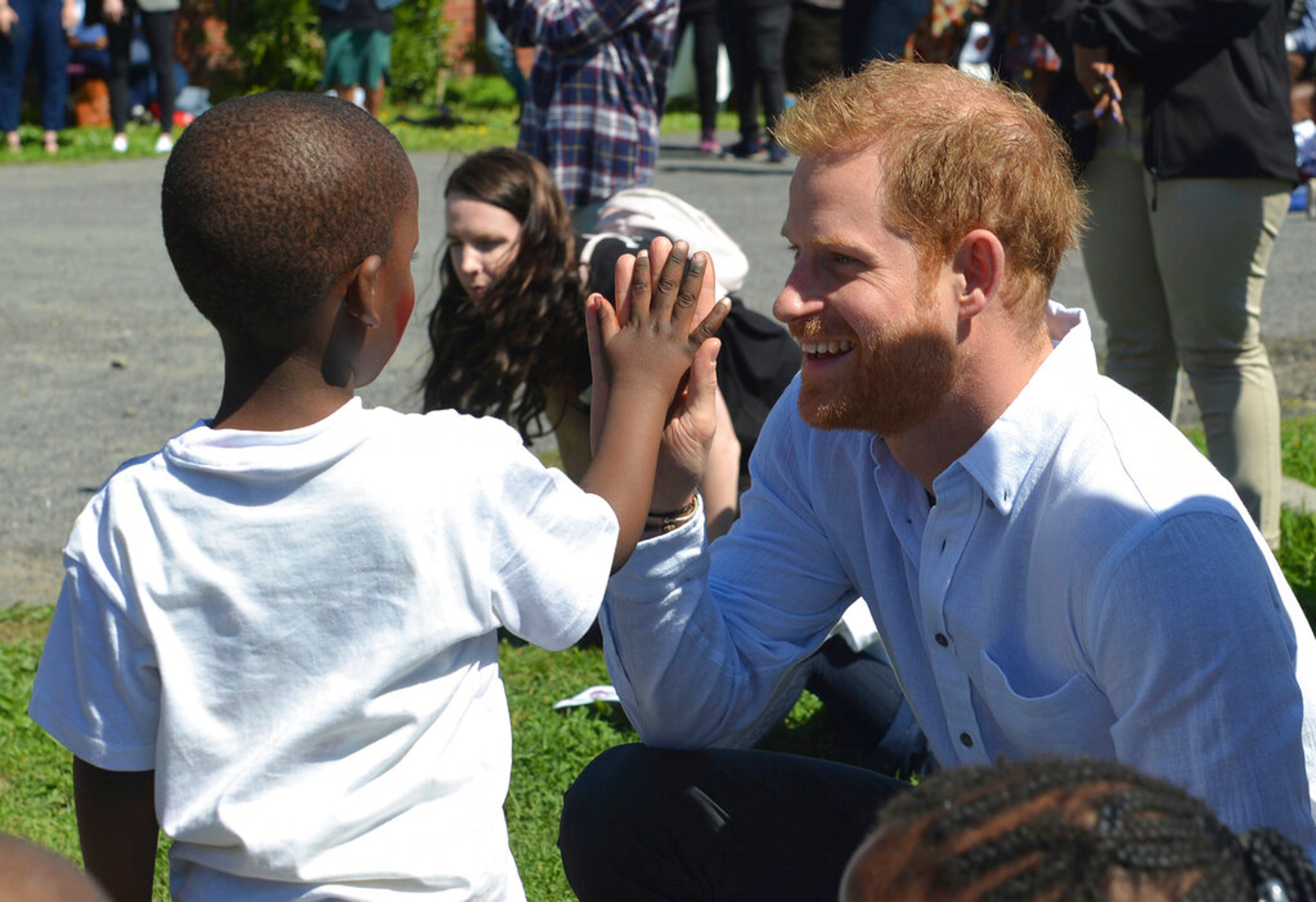 Britain's Prince Harry interacts with a child at the Nyanga Methodist Church in Cape Town, South Africa, Monday, Sept, 23, 2019, which houses a project where children are taught about their rights, self-awareness and safety, and are provided self-defence classes and female empowerment training to young girls in the community. The royal couple are starting their first official tour as a family with their infant son, Archie. (Courtney Africa / Africa News Agency via AP, Pool)