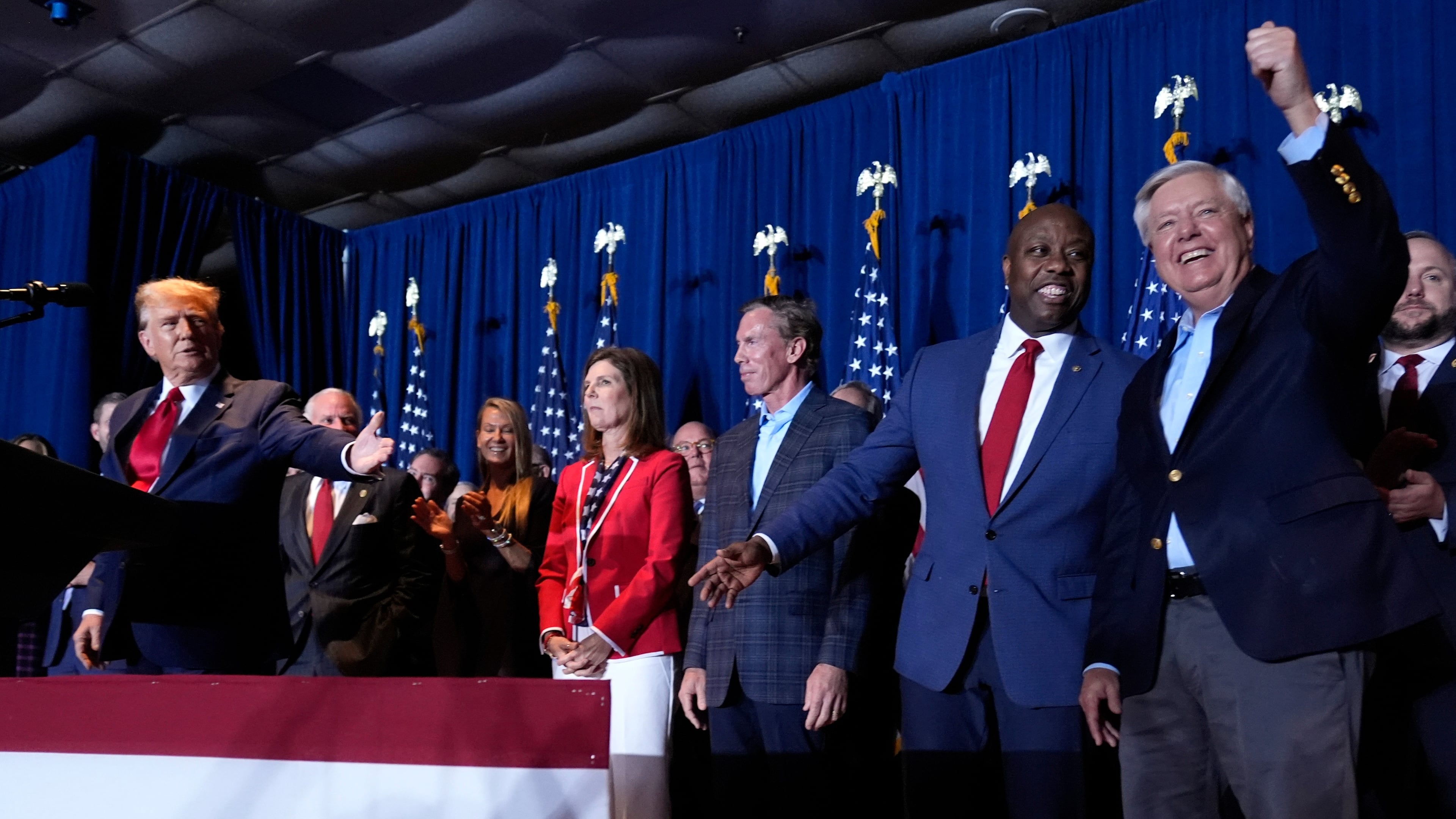FILE - Republican presidential candidate former President Donald Trump speaks as Sen. Tim Scott, R-S.C., and Sen. Lindsey Graham, R-S.C., listen, at a primary election night party at the South Carolina State Fairgrounds in Columbia, S.C., Feb. 24, 2024. (AP Photo/Andrew Harnik, File)