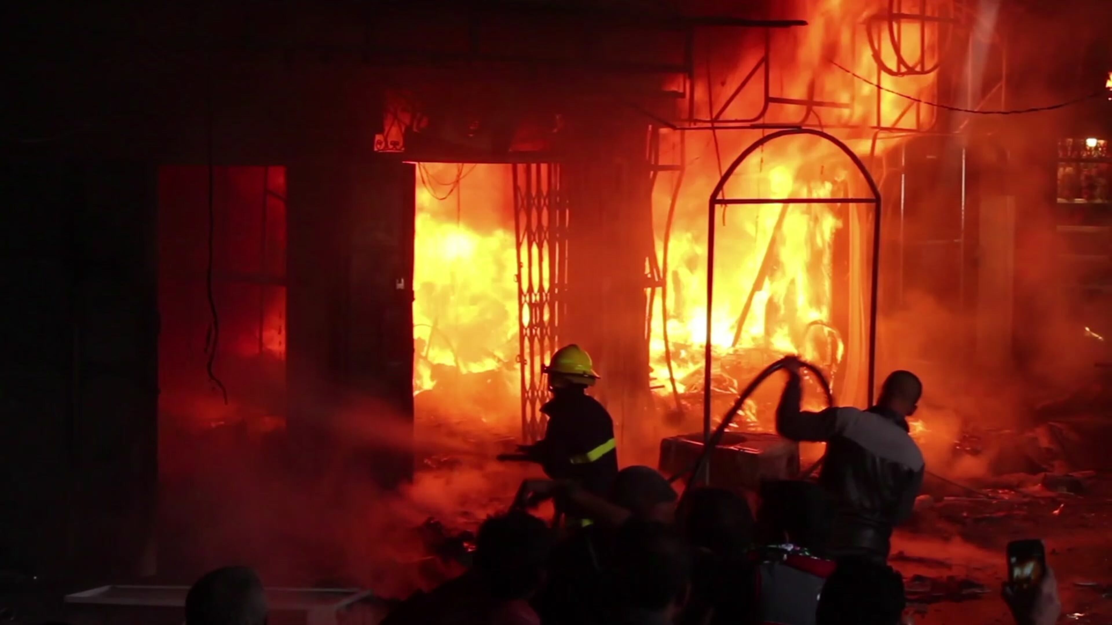 In this image taken from a video footage, a fireman tries to extinguish fire in multiple market stalls at Nabi Younus market in east Mosul, Iraq, Sunday, March 26, 2017. At least two people were killed and many others injured after three projectiles hit the busy Nabi Younus market in east Mosul on Sunday afternoon. (AP Photo)