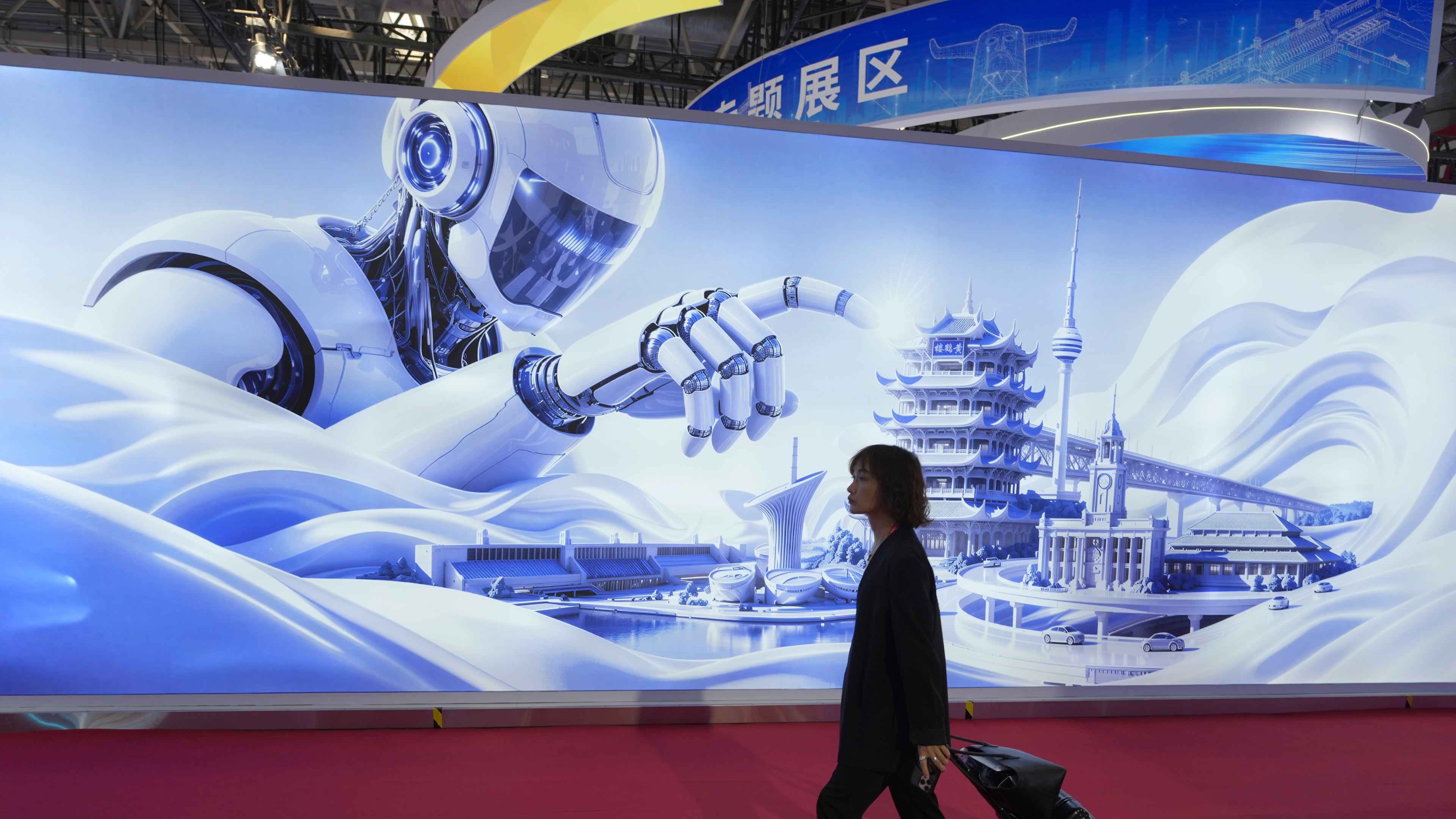 A woman passes a mural depicting a humanoid robot towering over iconic landmarks at the China International Supply Chain Expo in Beijing on Monday, June 22, 2026. (AP Photo/Ng Han Guan)