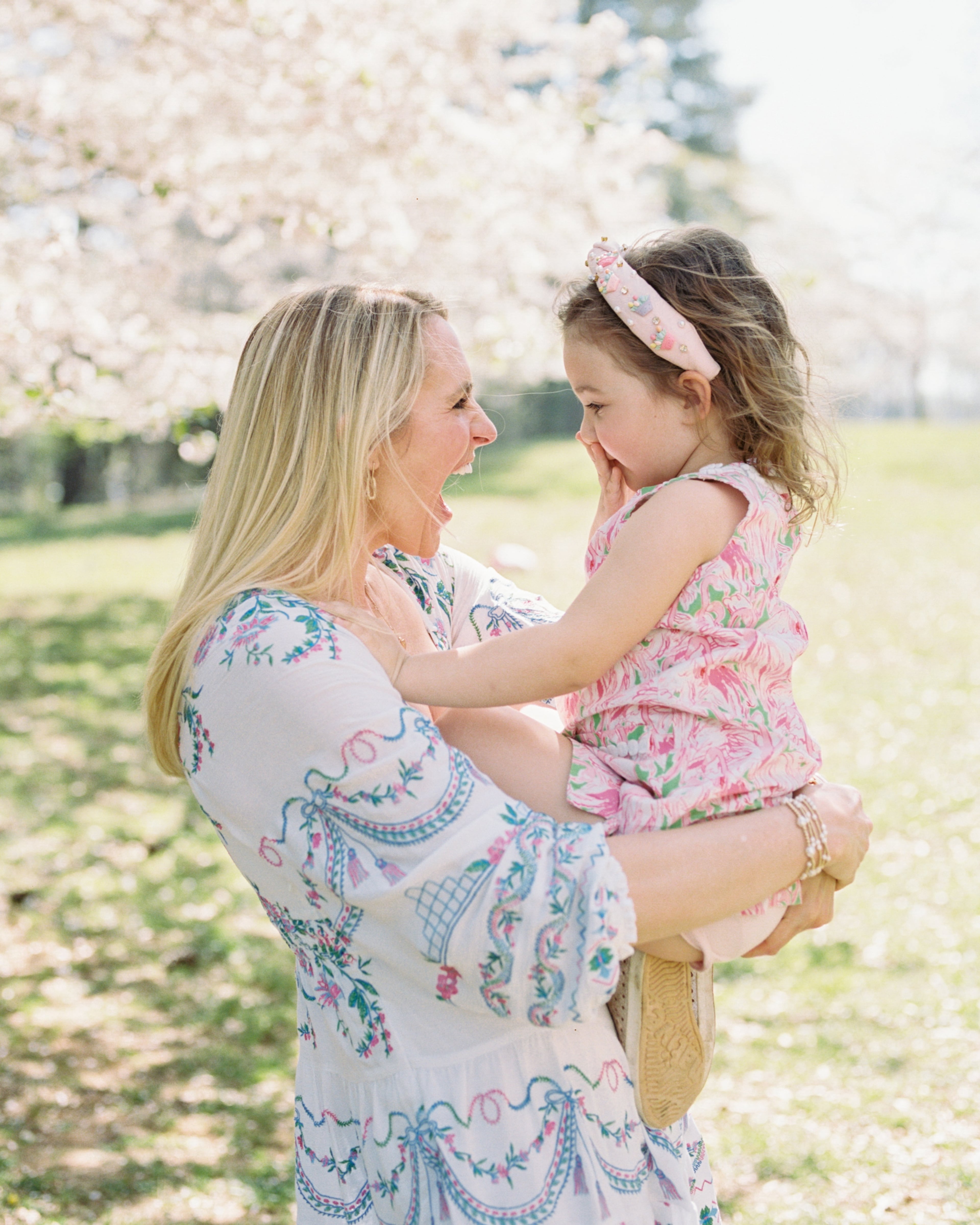 Atlanta-based parenting expert Katy Huie Harrison shares a playful moment with her daughter amidst the Atlanta magnolia blooms. (Courtesy of Brooke Whitney Photography)