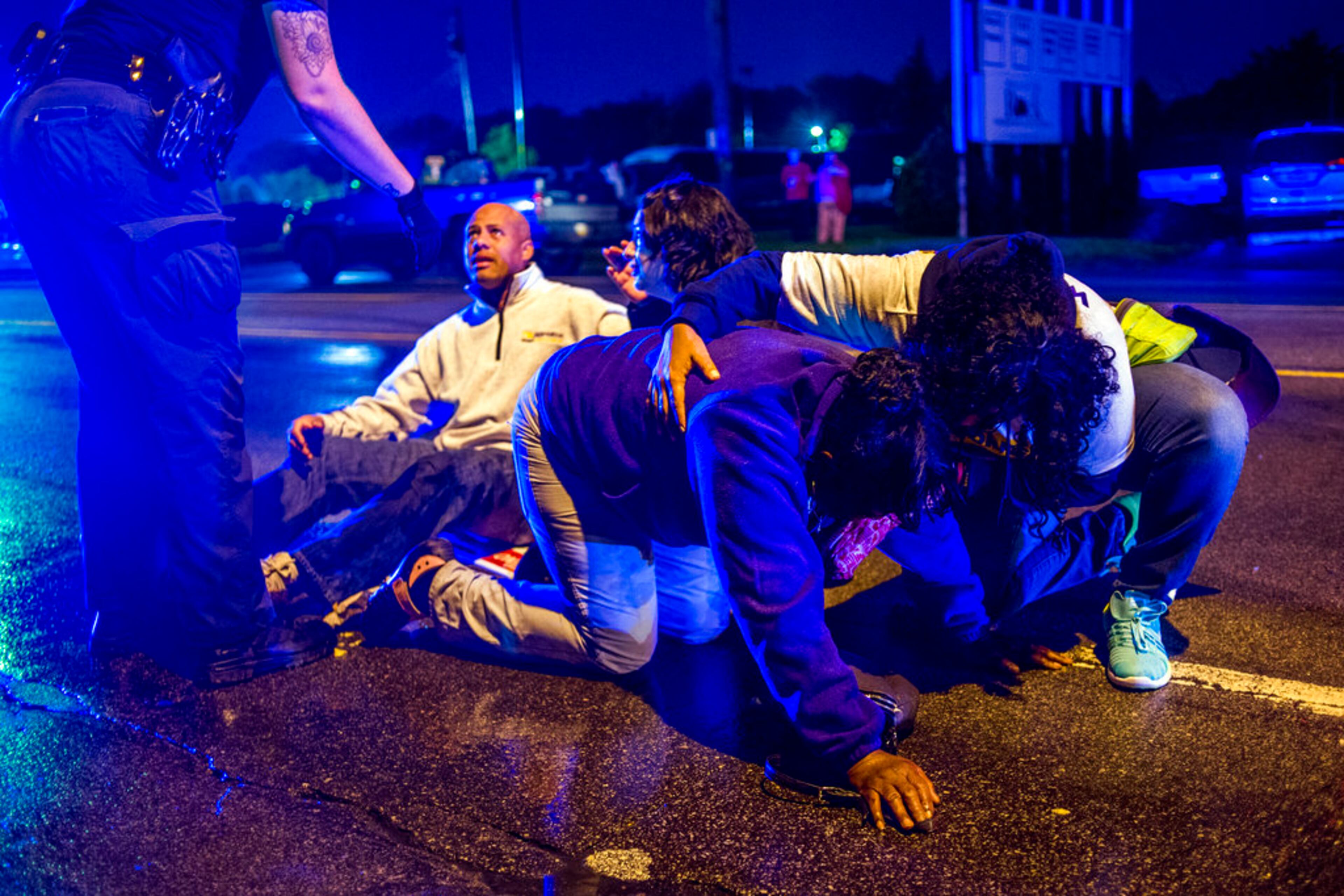 People gather to tend to protesters after several people were hospitalized when a truck collided with into protesters calling for the right to form unions Tuesday, Oct. 2, 2018, in Flint, Mich. Police said the collision appears to be an accident. (Jake May/The Flint Journal via AP)