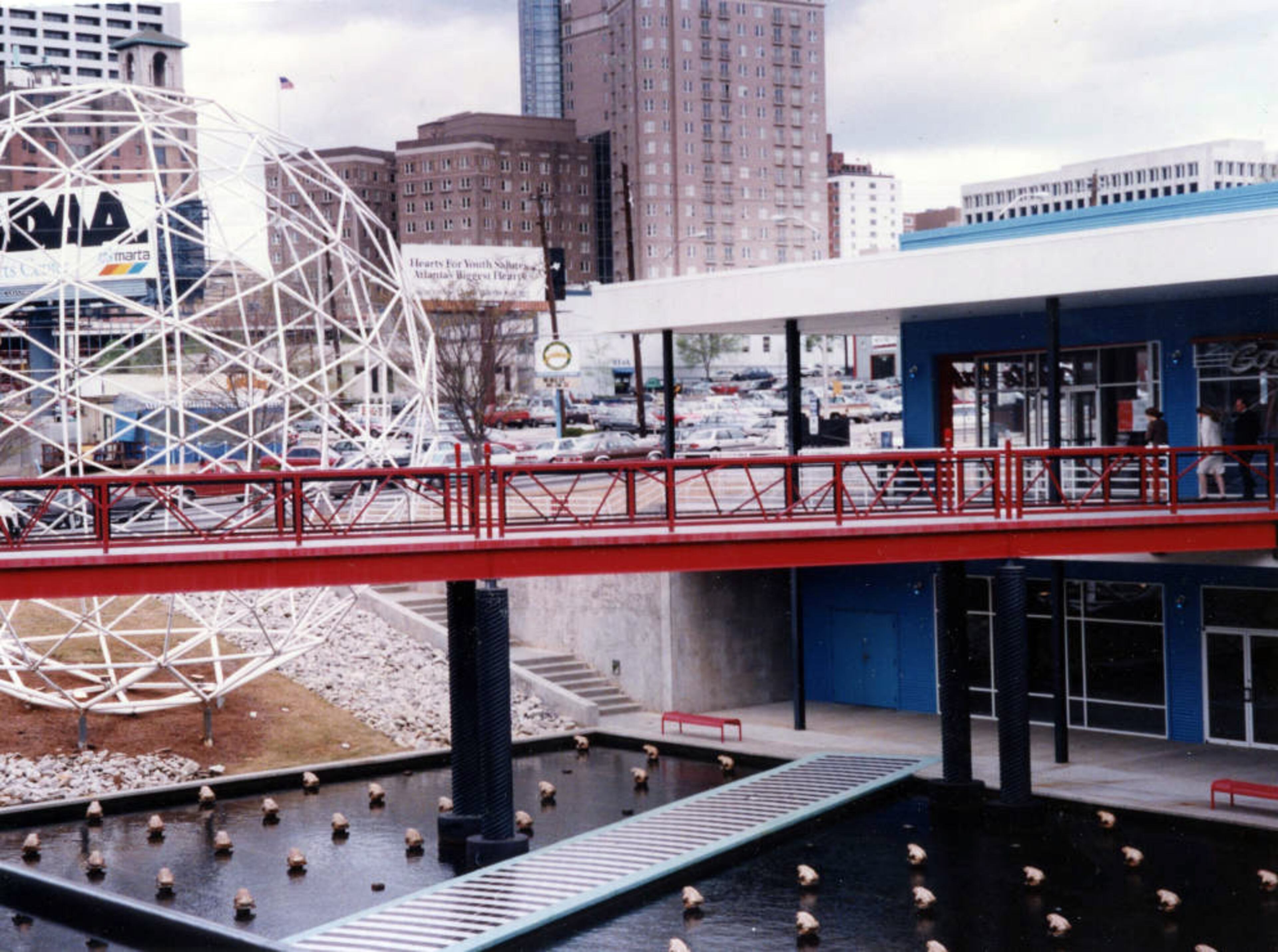 Pedestrian bridges and a pond dotted with golden frogs at the Rio Shopping Center, looking west toward Midtown on September 12, 1993. According to the story at the time, business was picking up there. It wouldn't last, though. The state-of-the-art center, which opened in 1988 at the corner of Piedmont and North aveneues, was torn down in 2000.