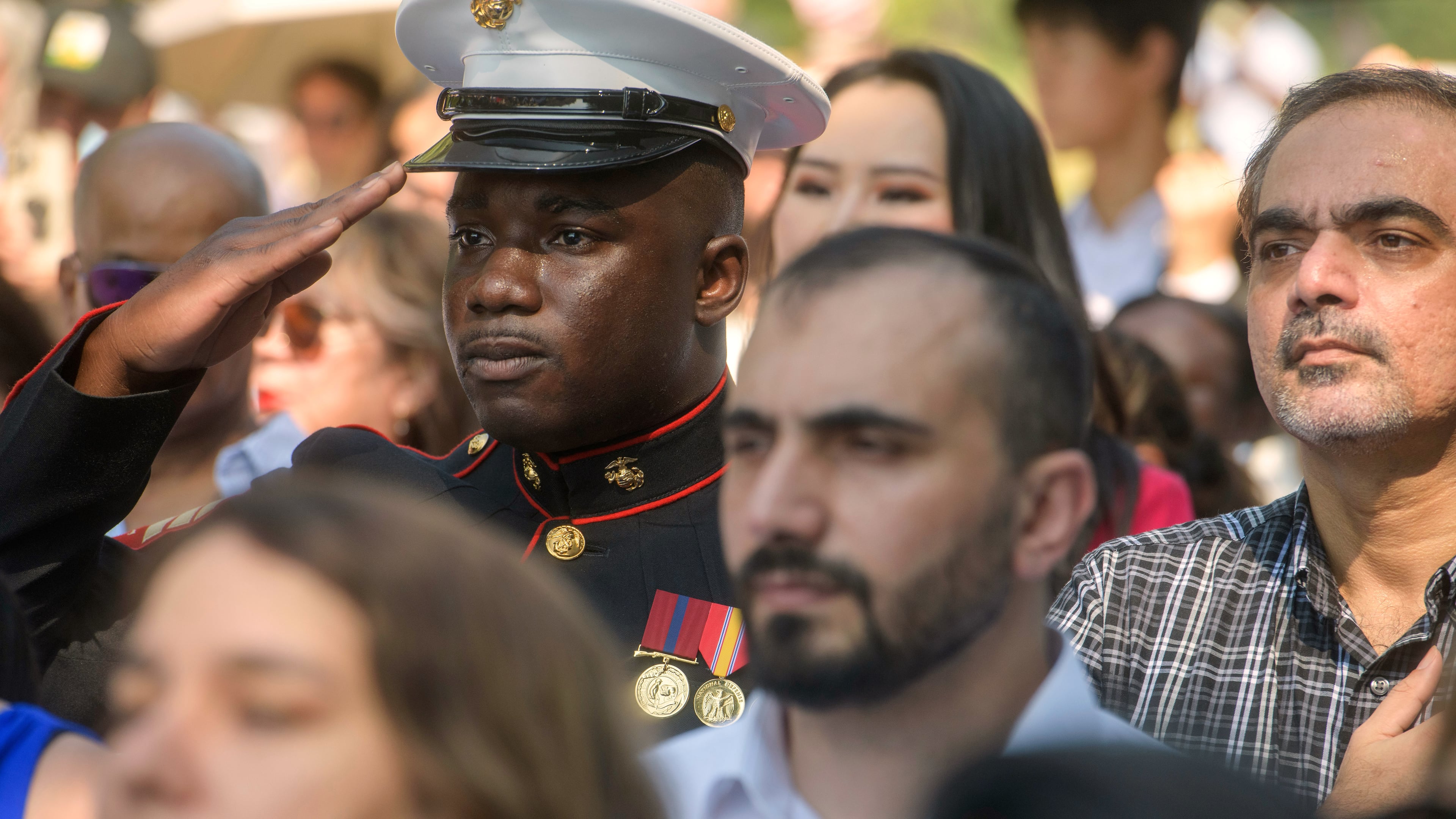 U.S. Marine Sgt. Diakaria Sangare, center, from Guinea, salutes the playing of the national anthem at a naturalization ceremony on Independence Day at George Washington's Mount Vernon, Saturday, July 4, 2026, in Alexandria, Va. (AP Photo/Rod Lamkey, Jr.)