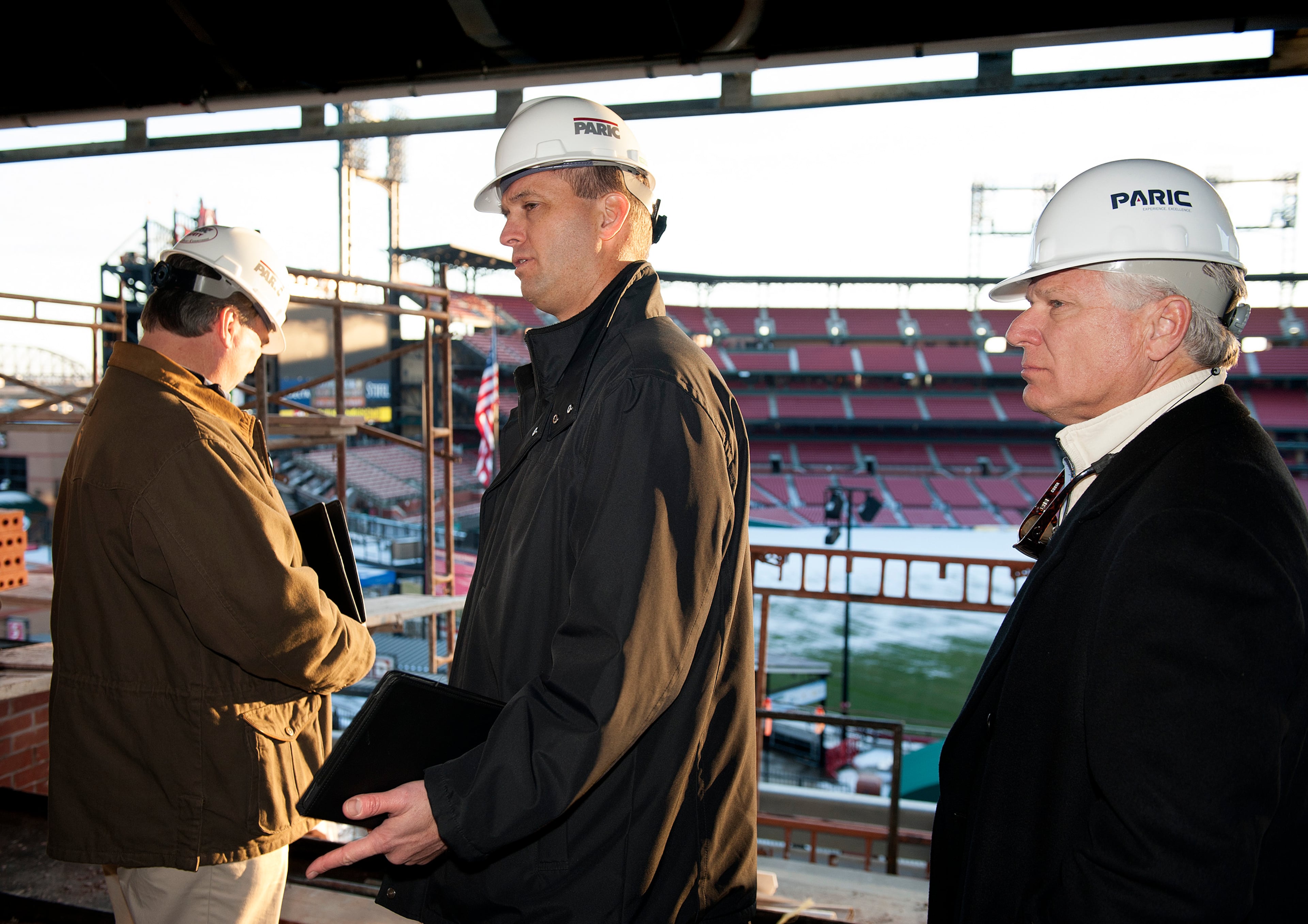 17 DEC. 2013 -- ST. LOUIS -- Atlanta Braves Executive Vice President of Sales and Marketing Derek Schiller (center) joins Braves Executive Vice President of Business Operations Mike Plant (left) and Braves General Manager Frank Wren (right) Tuesday, Dec. 17, 2013 in a partially-completed party room overlooking Busch Stadium in St. Louis during a tour of the stadium and adjoining Ballpark Village, a joint development of the St. Louis Cardinals and the Cordish Companies. The development, which features retail and entertainment tenants, is slated to open in phases beginning in March 2014 after several years of delays. Photo by Sid Hastings.