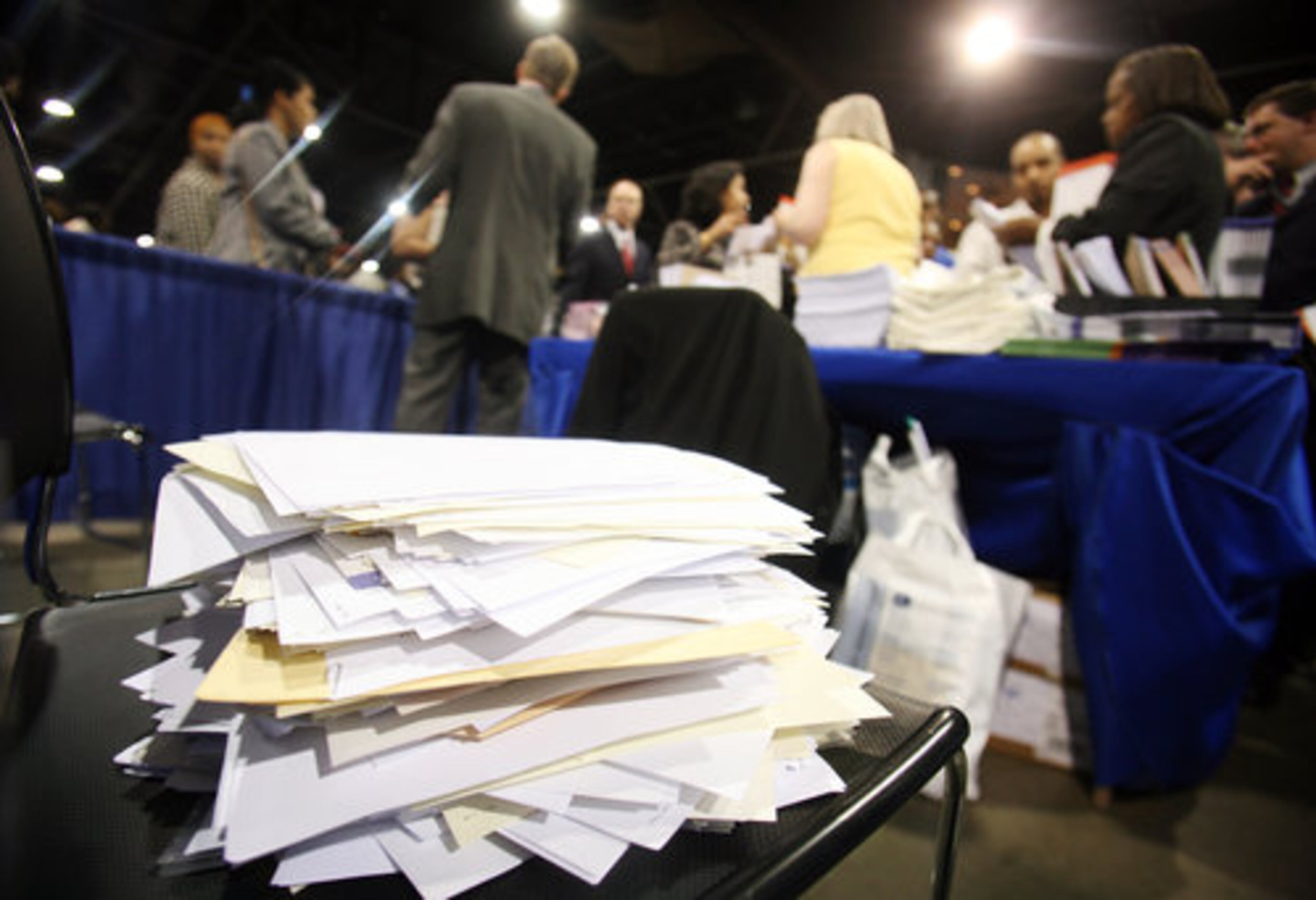 A stack of resumes sits behind the IRS employment booth.