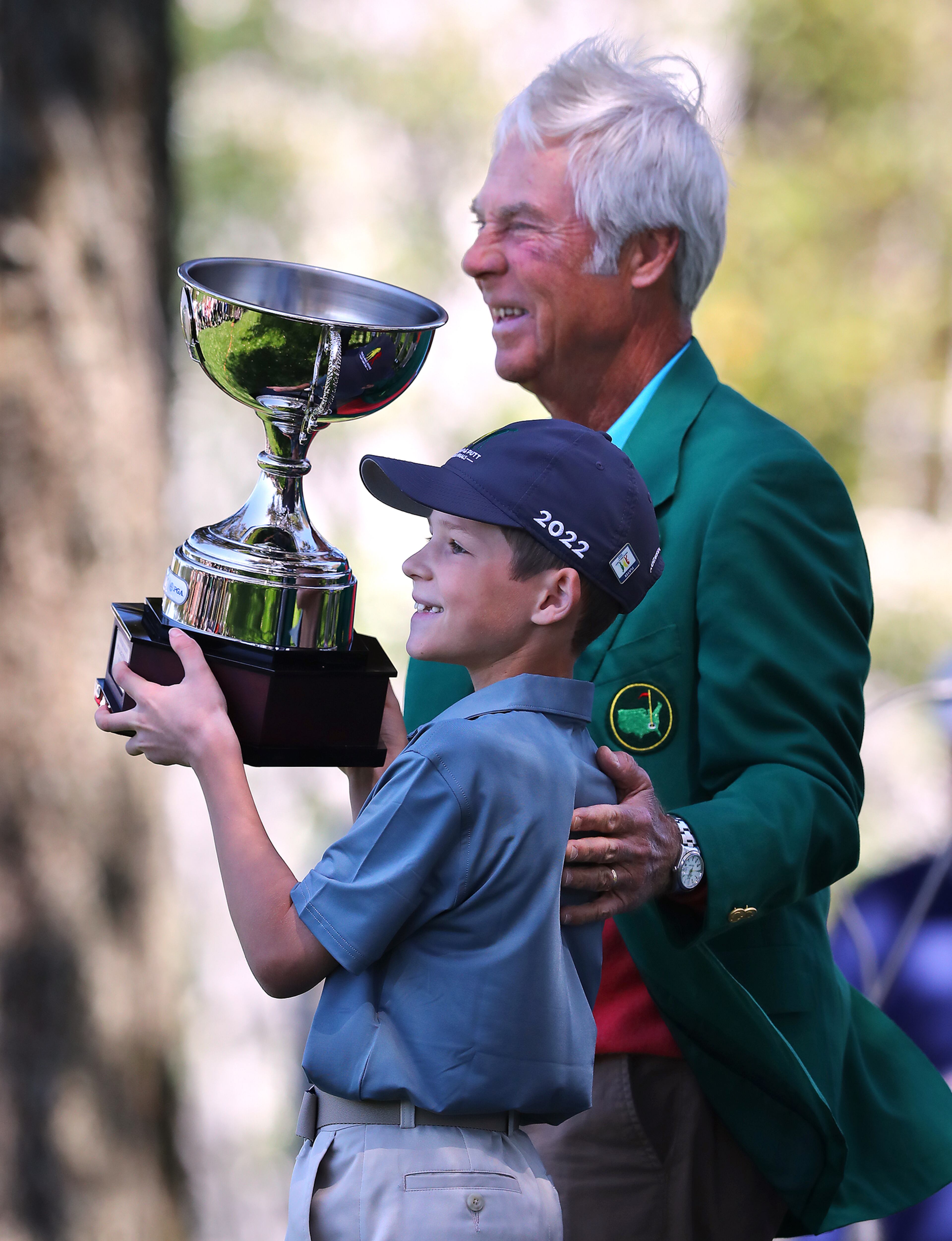 Two-time Masters winner Ben Crenshaw presents Hudson Knapp, Marietta, his overall championship trophy for winning the Drive, Chip and Putt National Finals for the boys 7-9 group at Augusta National Golf Club on Sunday, April 3, 2022, in Augusta. Curtis Compton / Curtis.Compton@ajc.com