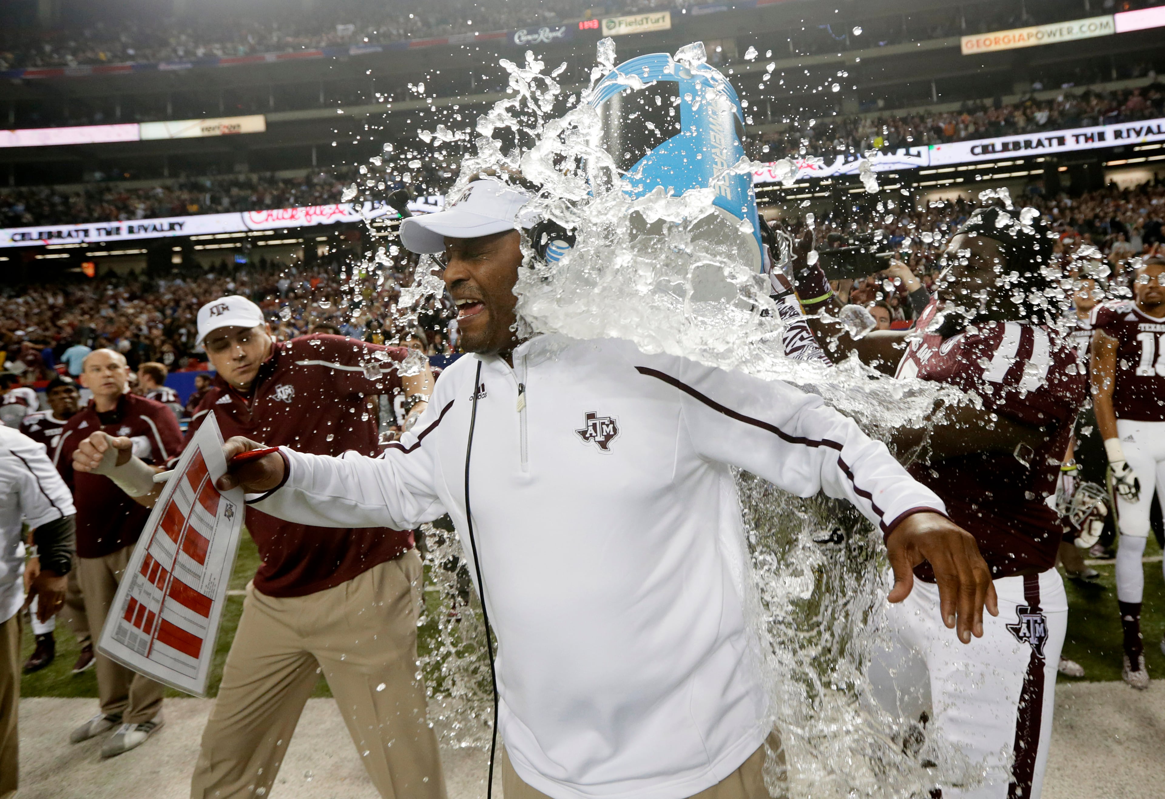 Texas A&M coach Kevin Sumlin is dunked in the closing seconds of a 52-48 win over Duke in the the Chick-fil-A Bowl NCAA college football game Tuesday, Dec. 31, 2013, in Atlanta.