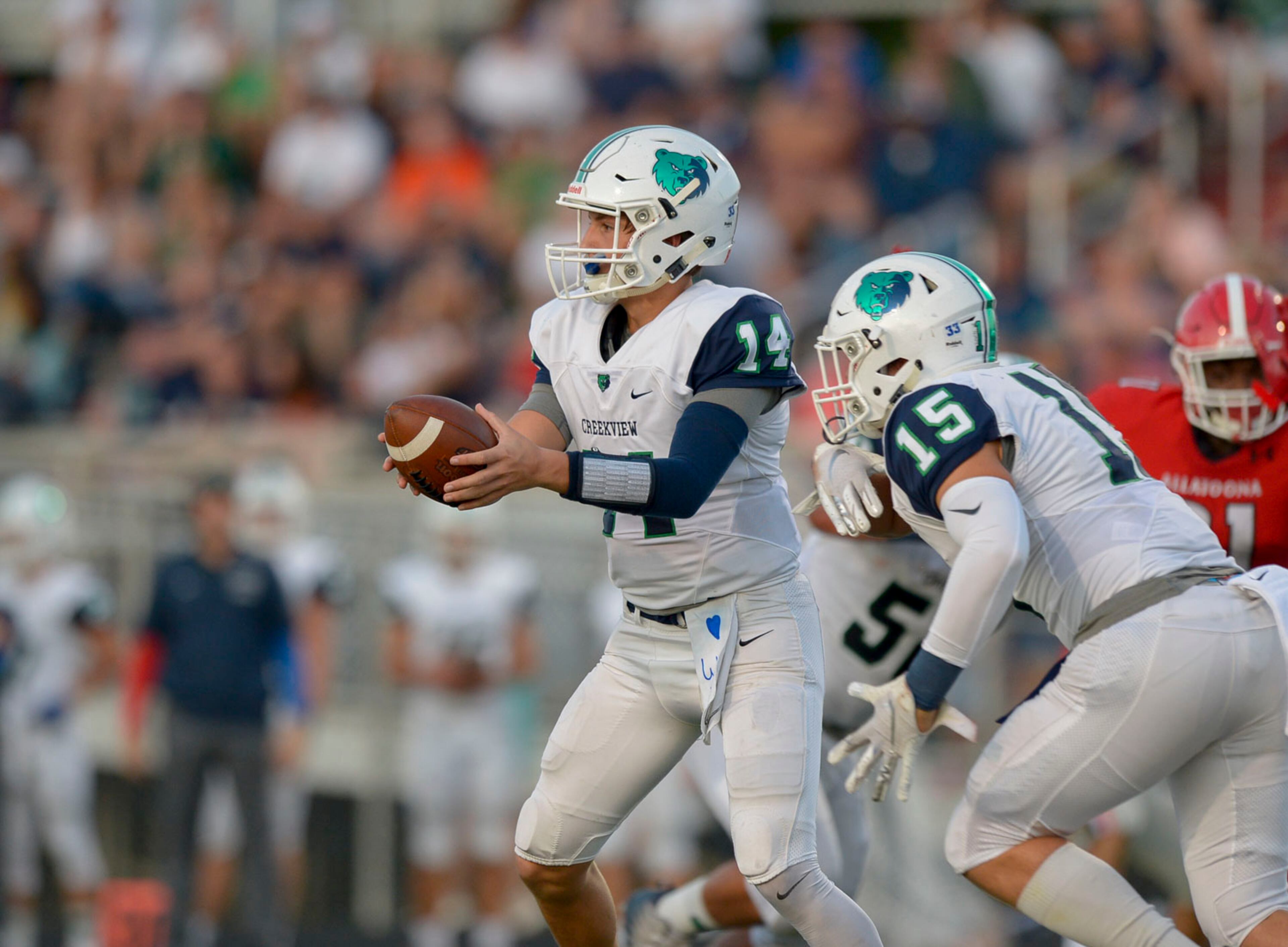 Creekview quarterback Brody Rhodes (14) fakes a handoff to wide receiver Tyler Stevens (15) in the first half of Friday's game at Allatoona. (Daniel Varnado/Special)