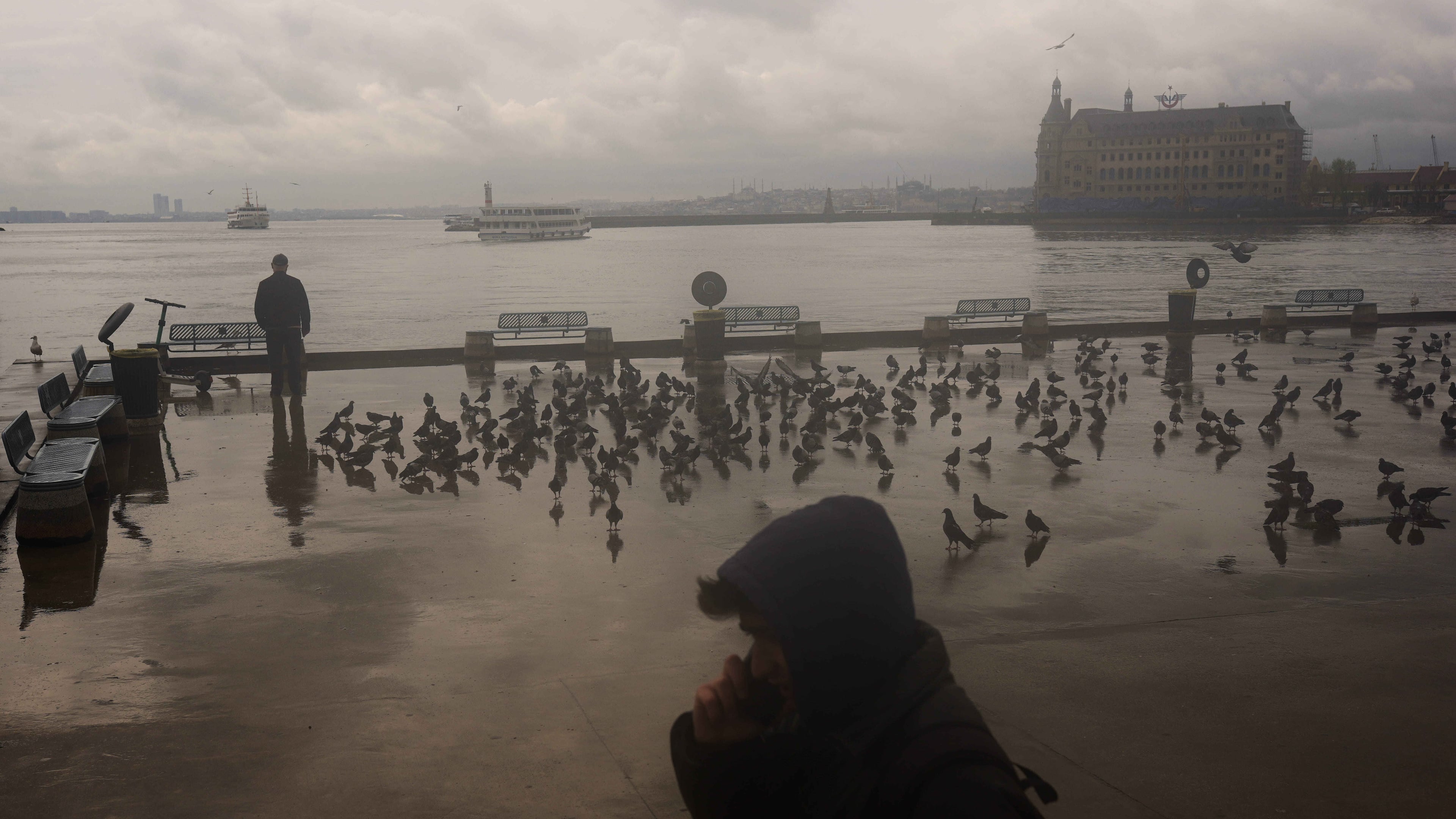 A man stands next to the Bosphorus at Kadikoy ferry terminal on a rainy day in Istanbul, Turkey, Wednesday, April 22, 2026. (AP Photo/Francisco Seco)