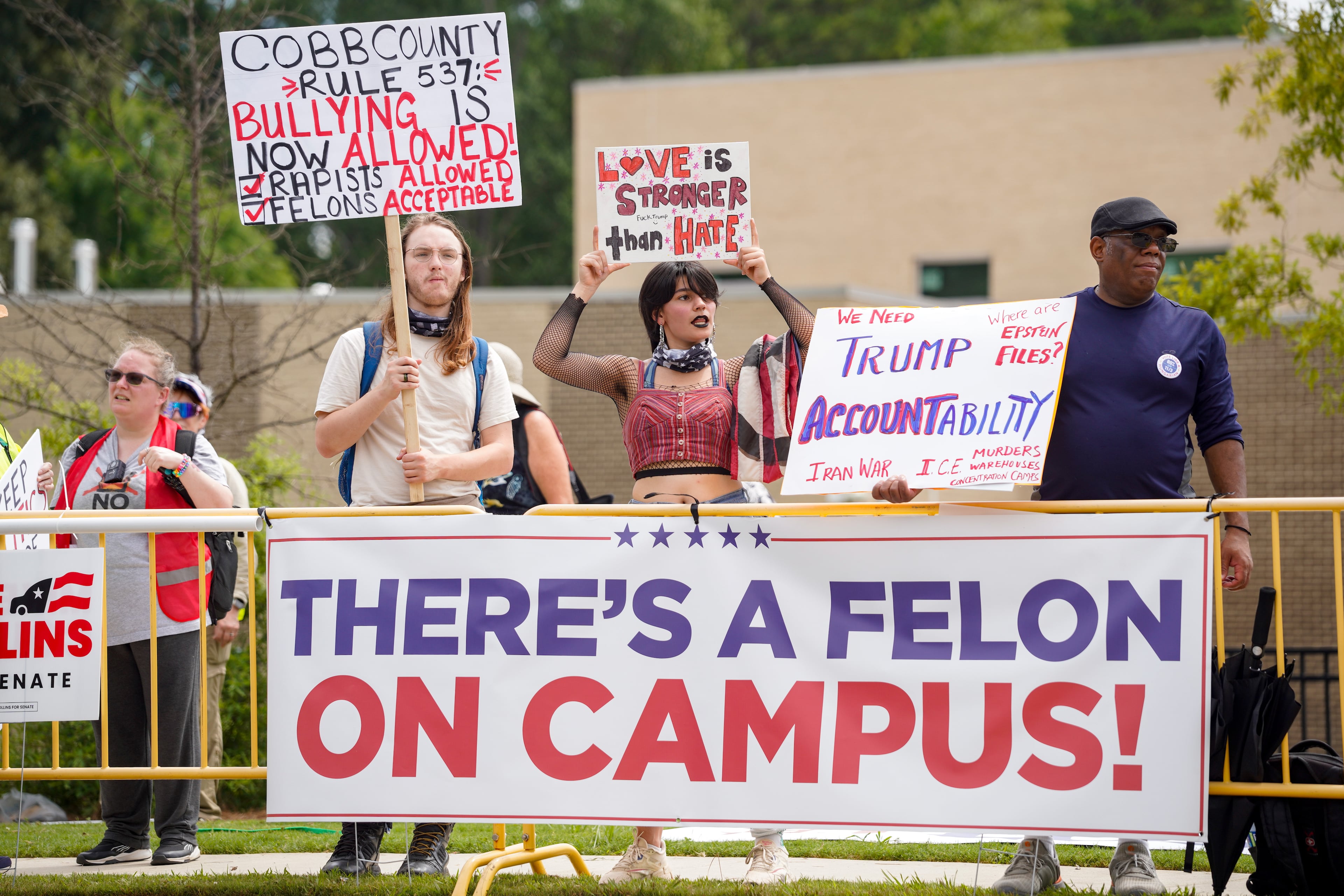 Protestors gather in Marietta while waiting for President Donald Trump to speak at Wheeler High School in Marietta on July 22, 2026. (Ben Hendren for the AJC)