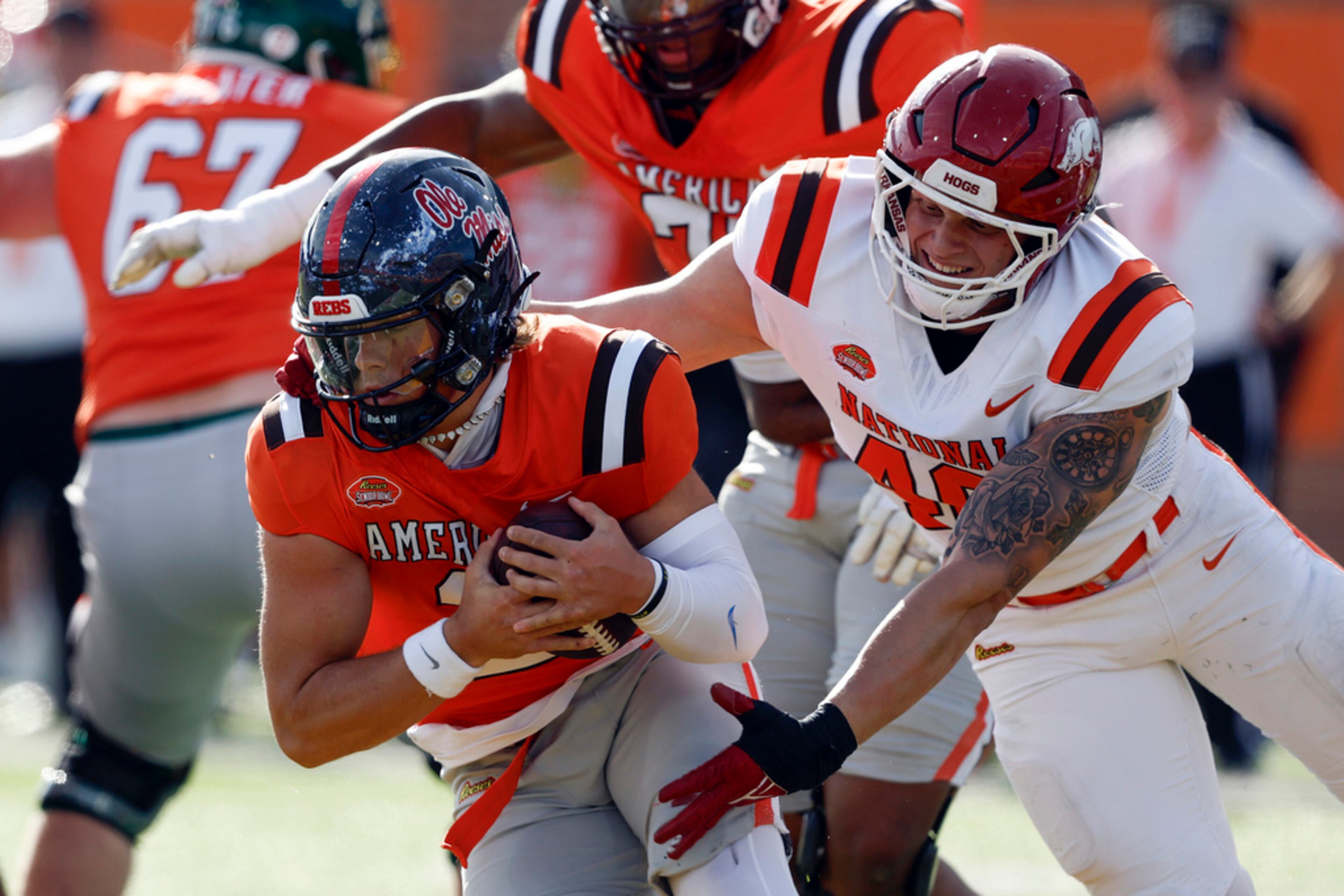 American team quarterback Jaxson Dart, left, of Mississippi, escapes pressure from National team defensive lineman Landon Jackson (40), of Arkansas, during the first half of the Senior Bowl NCAA college football game, Saturday, Feb. 1, 2025, in Mobile, Ala. (AP Photo/Butch Dill)