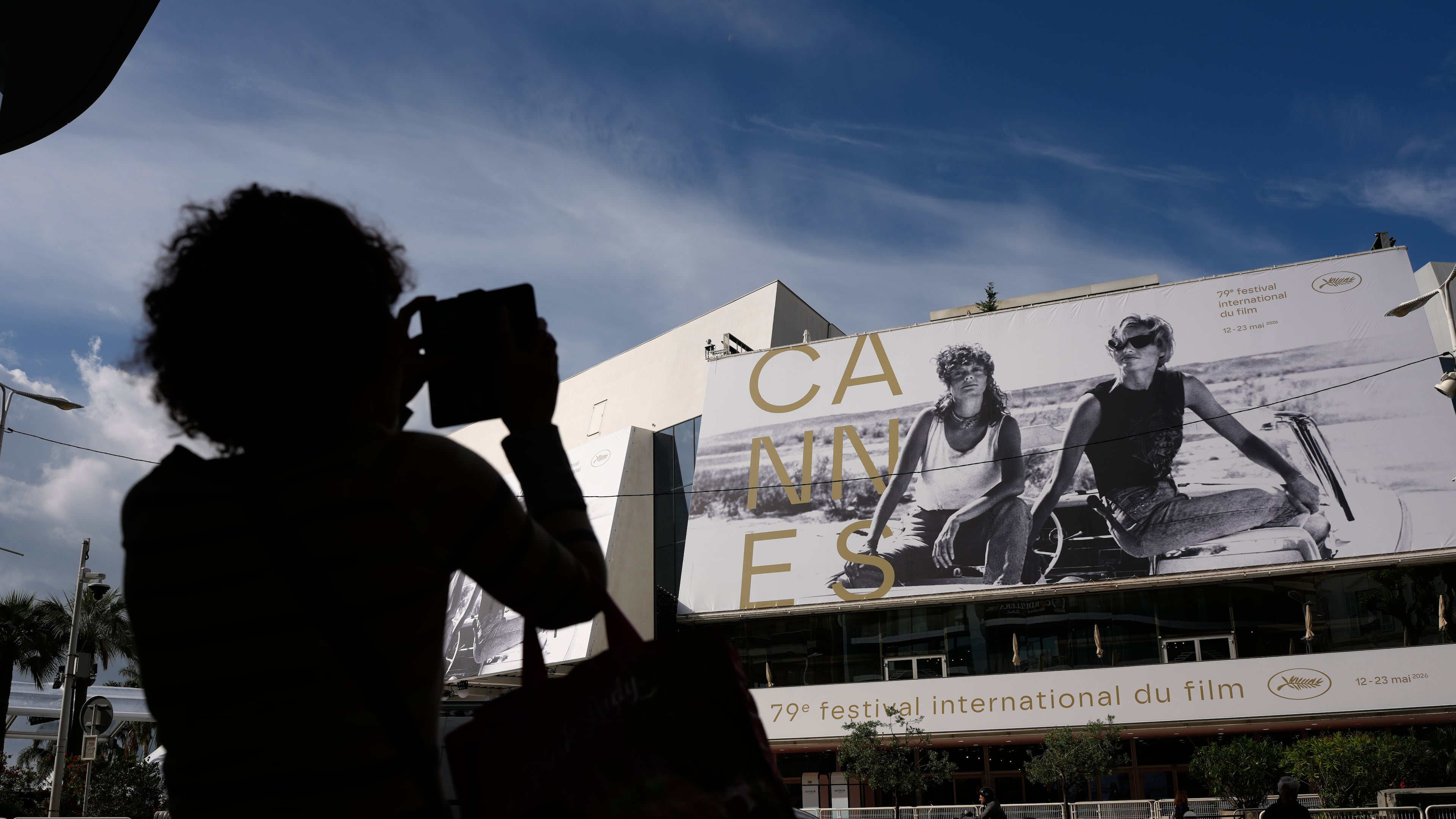 A person takes a photo outside the Palais des Festivals during preparations for the 79th international film festival, Cannes, southern France, Monday, May 11, 2026. (AP Photo/John Locher)