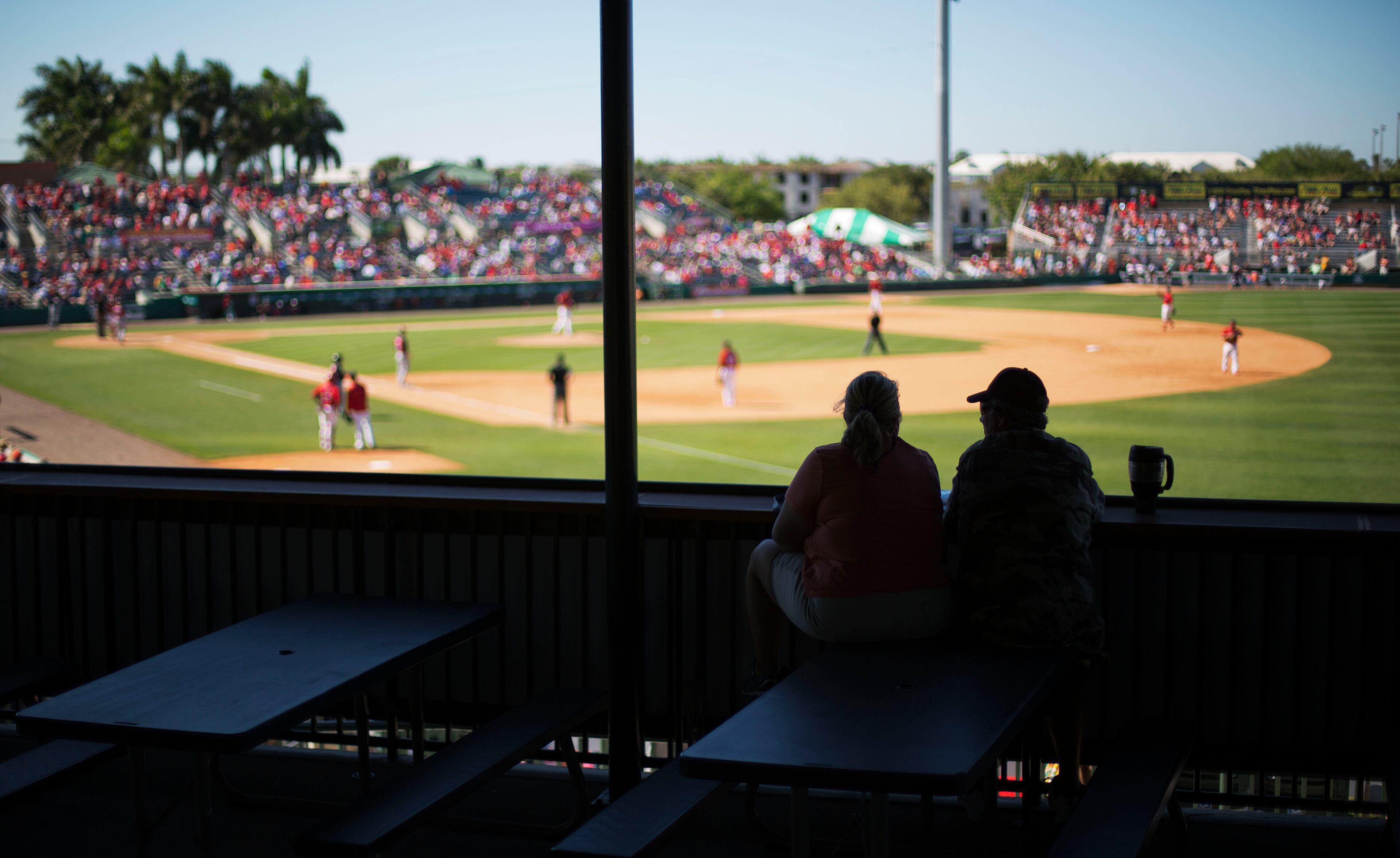 Spectators watch from the outfield during the ninth inning of an exhibition spring training baseball game between the Atlanta Braves and the St. Louis Cardinals, Thursday, March 13, 2014, in Jupiter, Fla.