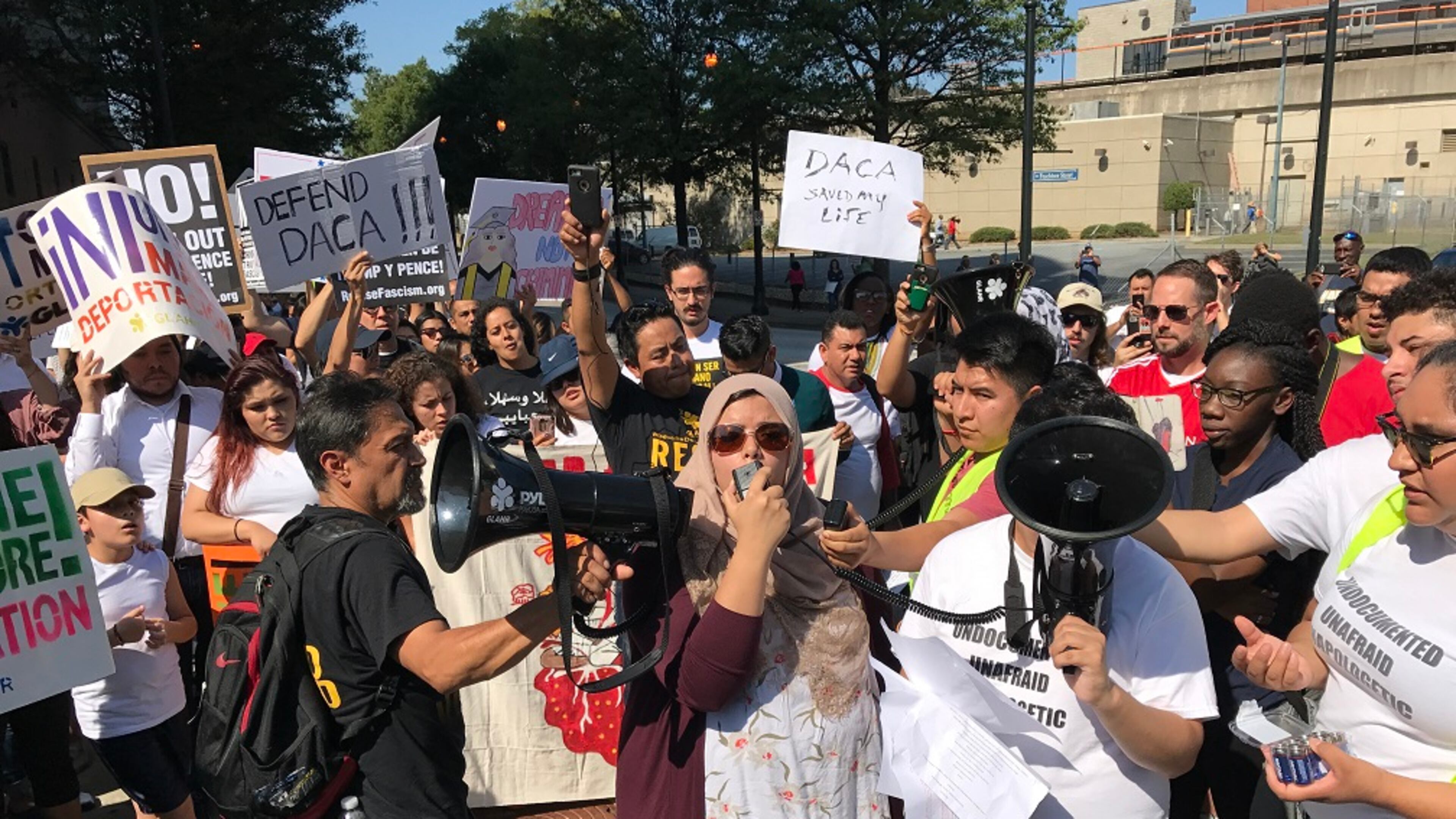 Aisha Yaqoob, center with microphone, was among hundreds of activists who demonstrated outside the Atlanta City Detention Center Monday, Sept. 4, 2017, in favor of the Deferred Action for Childhood Arrivals program. Jeremy Redmon/jredmon@ajc.com