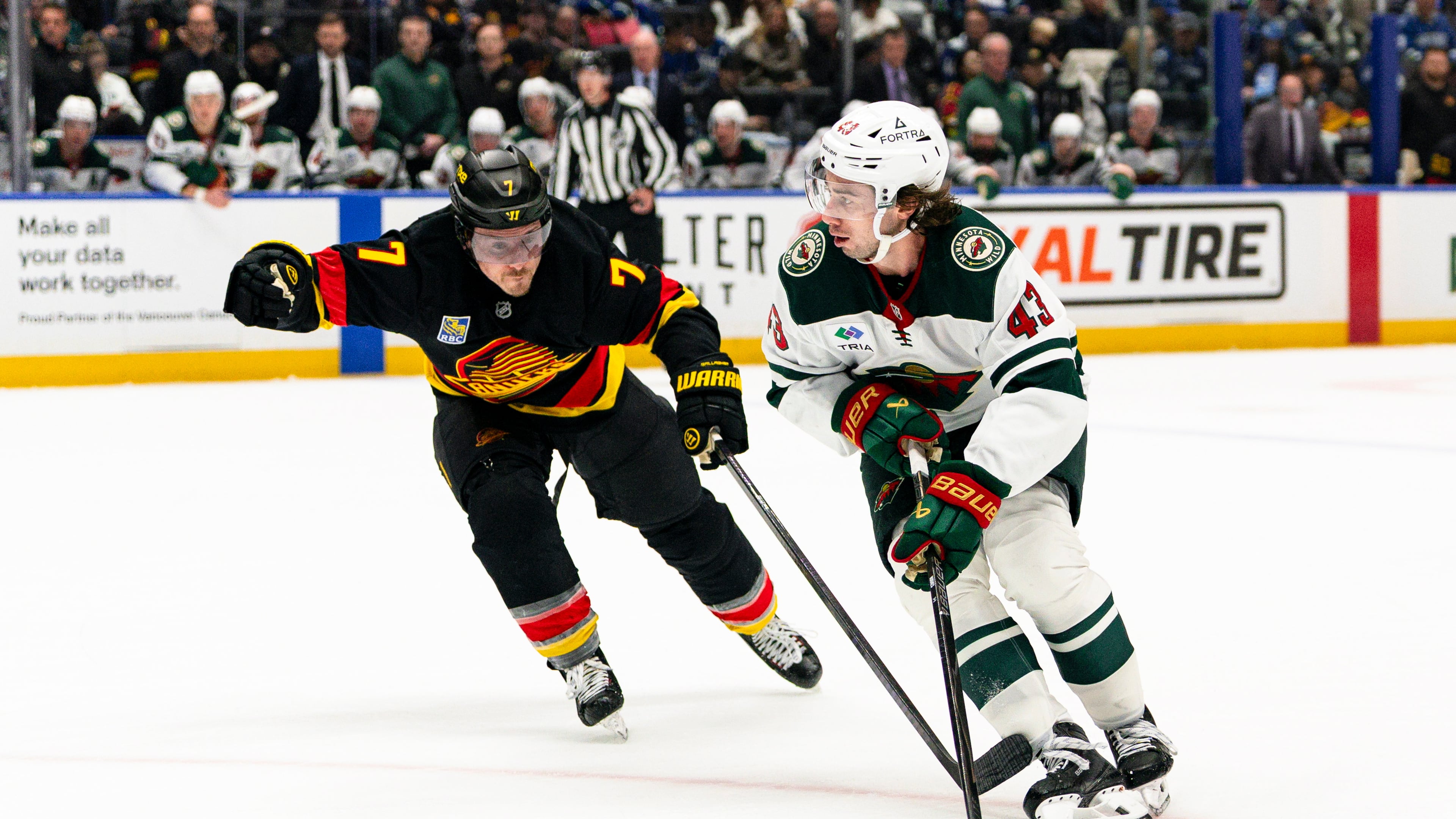 Minnesota Wild's Quinn Hughes (43) skates past Vancouver Canucks' Brendan Gallagher (7) during the second period of an NHL hockey game, in Vancouver, British Columbia, Sunday, Oct. 25, 2026. (Jacob Mallari/The Canadian Press via AP)
