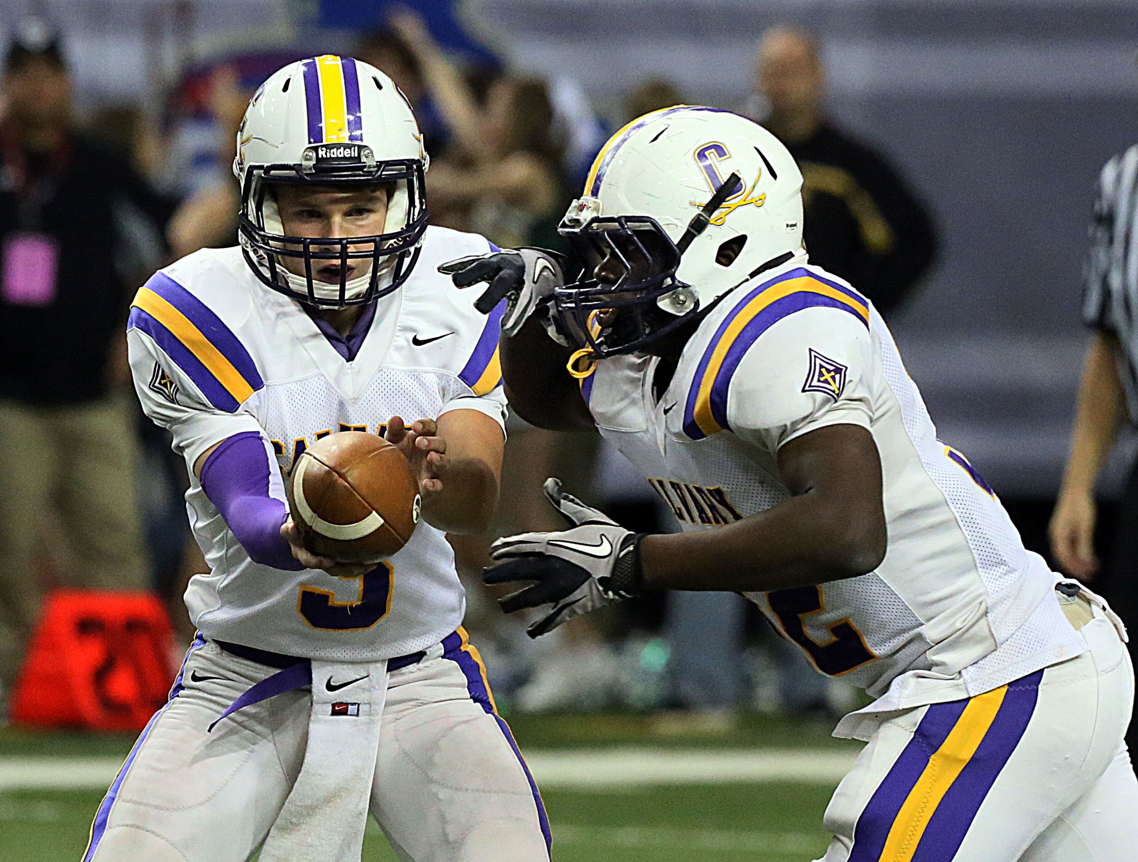 Calvary Day School (Savannah) Quarterback # 3 Michael Peterson hands off to # 32 Robert Heyward in the game against the Aquinas High School (Augusta)during the GHSA Football A-Private State Championship at the Georgia Dome in Atlanta on Friday December 13th, 2013.