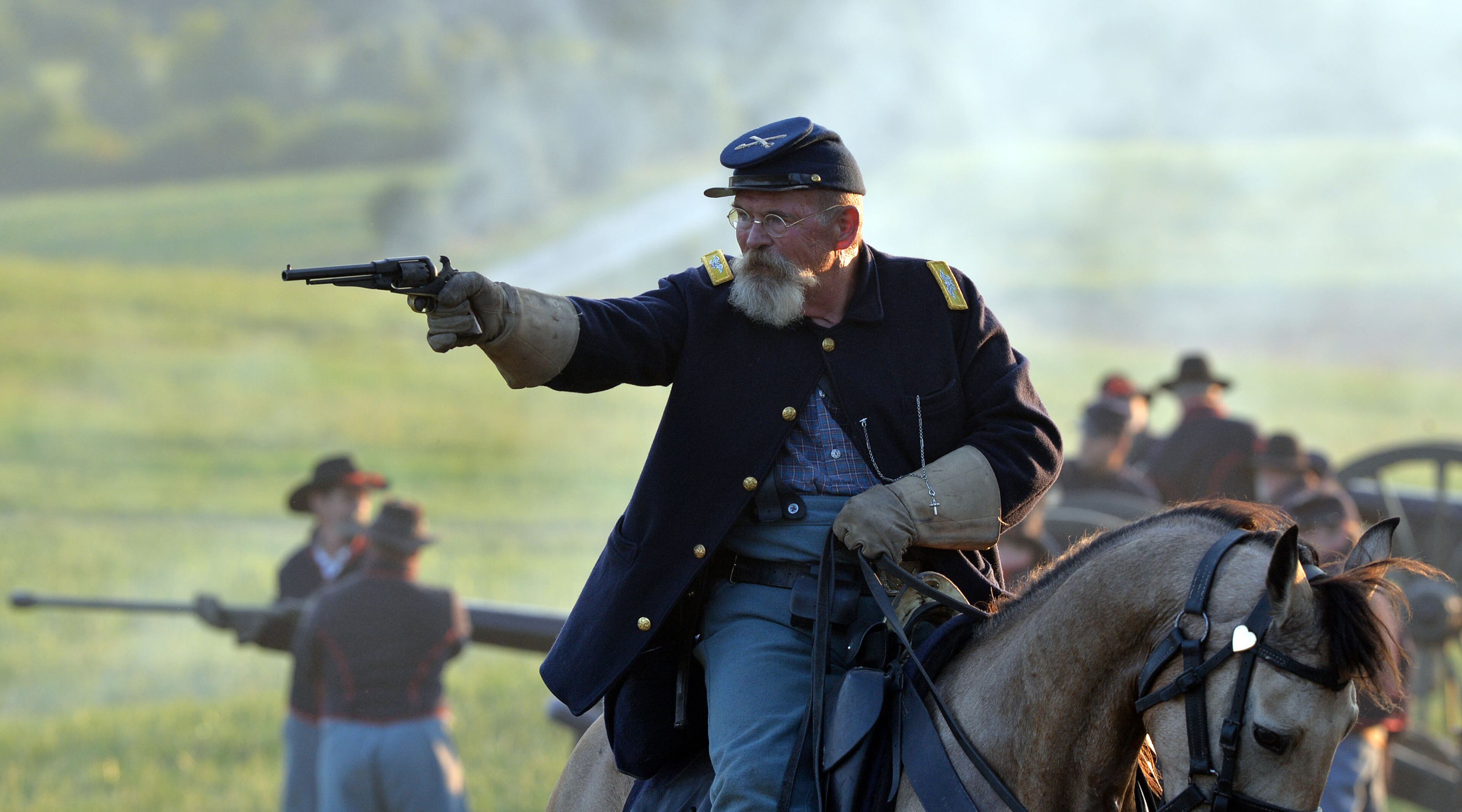 A Union cavalryman fires his pistol. Confederate and Union reenactors recreate the Battle of Utoy Creek during the Atlanta Campaign's Battle of Atlanta re-enactment at the Nash Farm Battlefield Friday, September 19, 2014. Thousands of re-enactors and spectators are expected to descend on Nash Farm Battlefield for this weekend's Battle of Atlanta events starting Friday and ending Sunday afternoon. Kilpatrick's Raid, the Battle of Cheatham's Hill, and Battle of Atlanta will be reenacted Saturday and Sunday. Confederate and Federal troops are in separate encampments about a 1/2 mile apart at the site. KENT D. JOHNSON / KDJOHNSON@AJC.COM