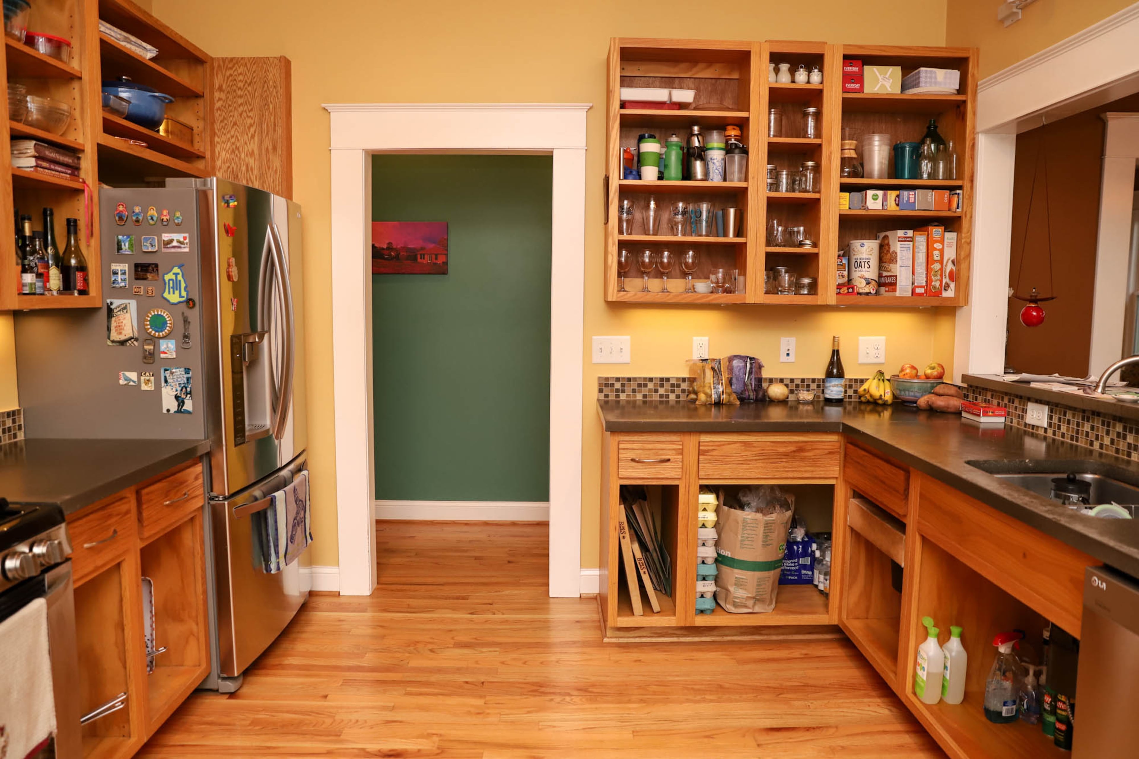 The homeowner opted to leave the doors off the custom red oak cabinets, because his budget was limited. The brown backsplash in the kitchen matches the blue tile in the master bathroom shower.