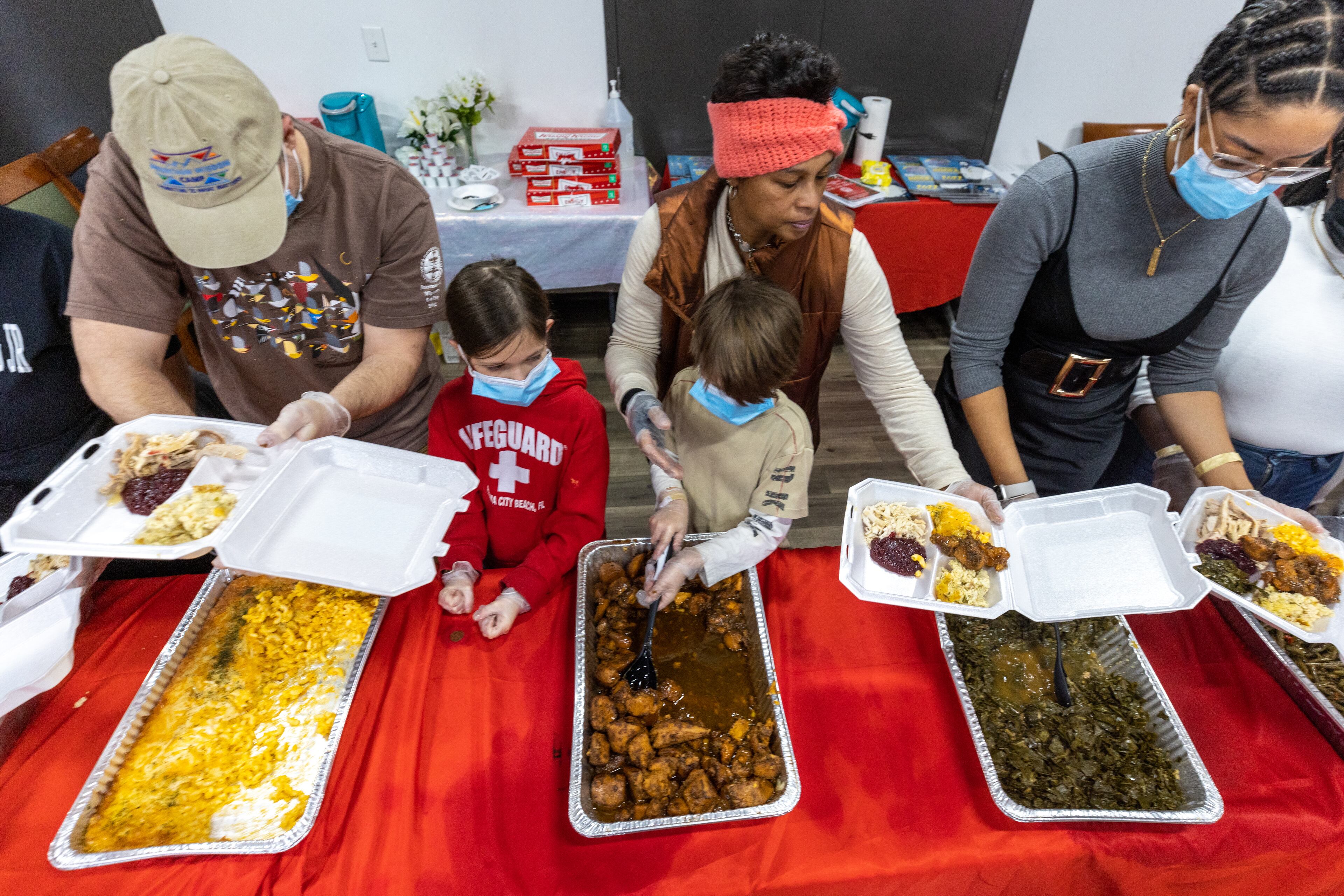 Kendra Lewis (center) helps volunteers put together some of the more than 550 hot Thanksgiving day meals that will be delivered to the community at the Hosea Helps headquarters in Atlanta on Thursday, November 24, 2022. (Steve Schaefer/steve.schaefer@ajc.com)