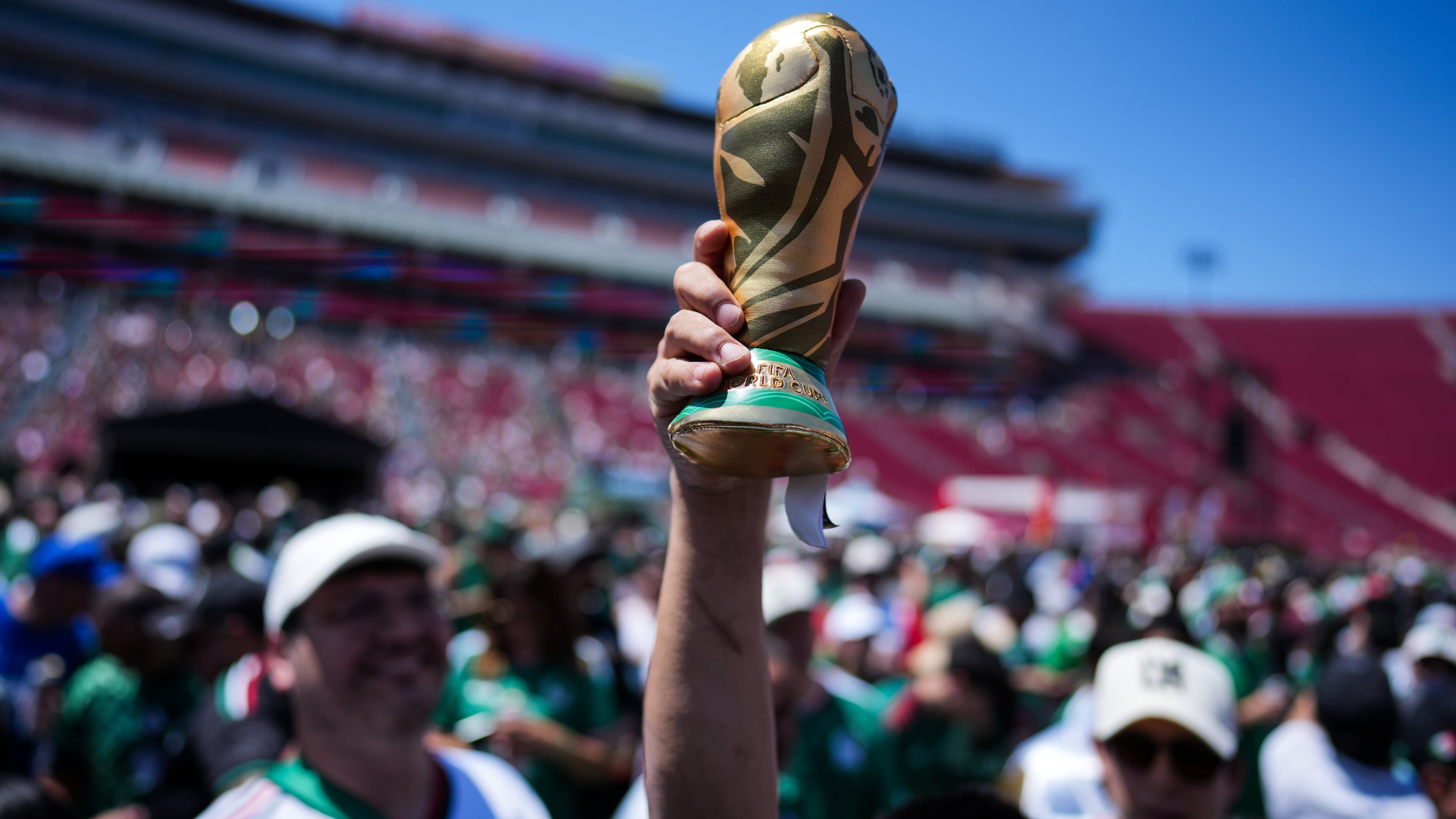 A fan holds up a replica of the World Cup trophy at a fan festival at the Los Angeles Memorial Coliseum in Los Angeles, Thursday, June 11, 2026, during a live broadcast of the World Cup soccer match between Mexico and South Africa. (AP Photo/Jae C. Hong)
