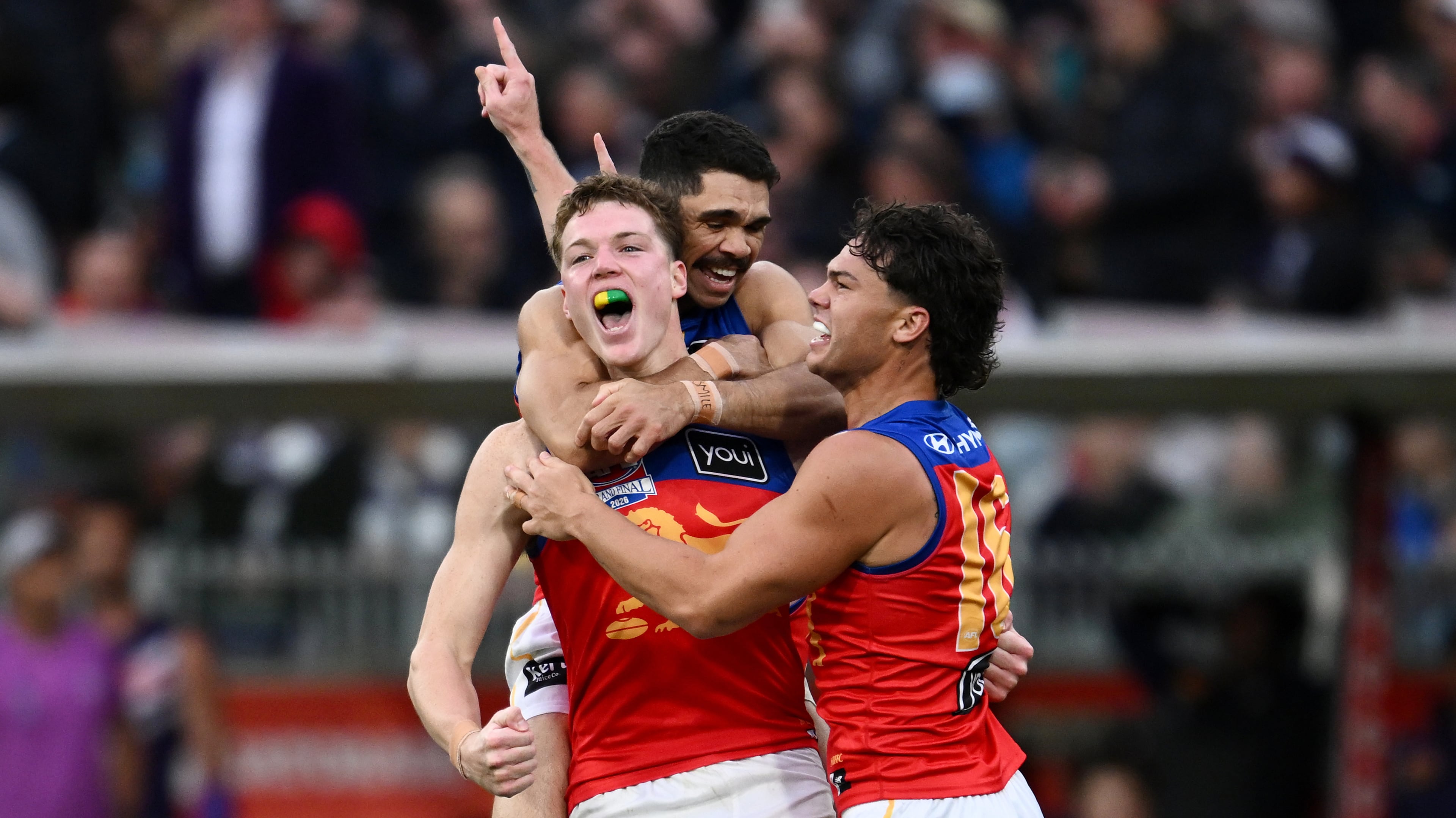 Brisbane Lions players Logan Morris, center, Charlie Cameron, rear, and Cam Rayner celebrate their win over the Fremantle Dockers in the Australian Football League grand final in Melbourne, Australia Saturday, Sept. 26, 2026. (Joel Carrett/AAP Image via AP)