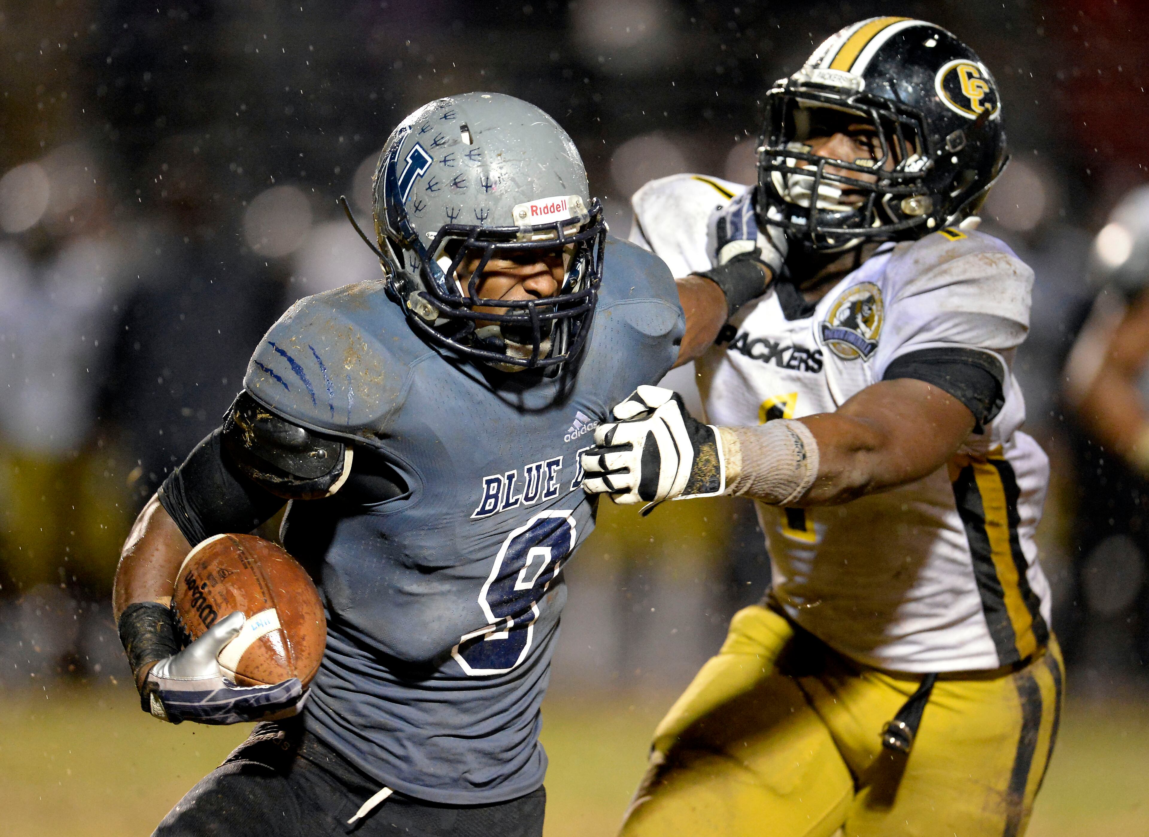 Norcross running back Josh Boyd (9) stiff arms Colquitt linebacker CJ Johnson (1) in the second half of their AAAAAA semifinal game at Blue Devil Stadium on Friday, Dec. 6, 2013, in Norcross, Ga.