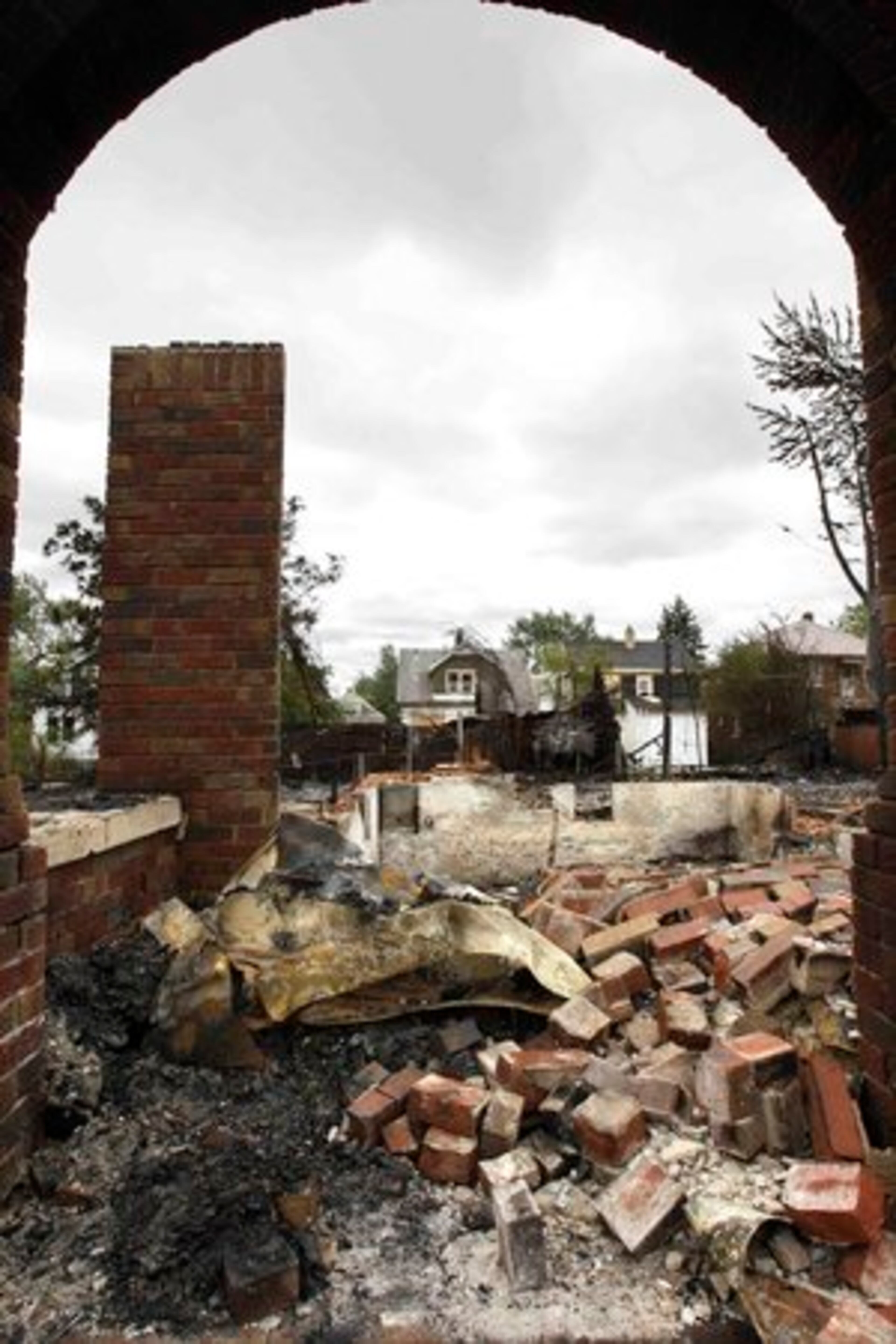 A burned home is seen through a remaining entryway of another home on Detroit's east side, Wednesday, Sept. 8, 2010.
