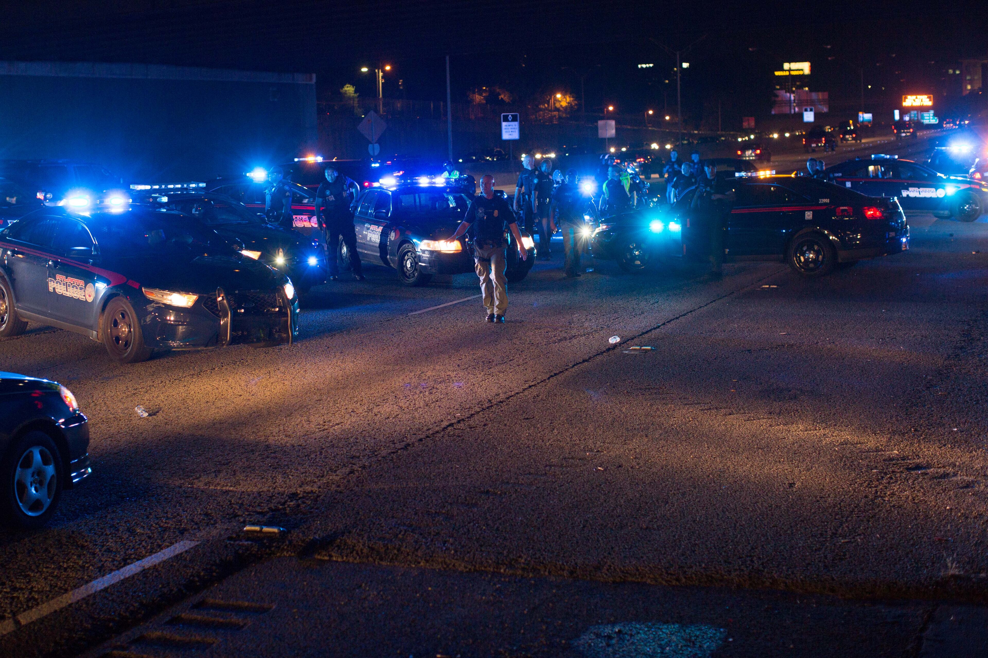 Atlanta Police officers clear I-75 northbound after demonstrators briefly shut it down, Thursday, July 7, 2016, in Atlanta, in response to the death of Alton Sterling, 37, who was killed by Baton Rouge police outside of a convenience store where he was selling CDs, and Philando Castile, who was shot and killed when Minnesota police stopped him for a traffic violation on Wednesday evening. BRANDEN CAMP/SPECIAL
