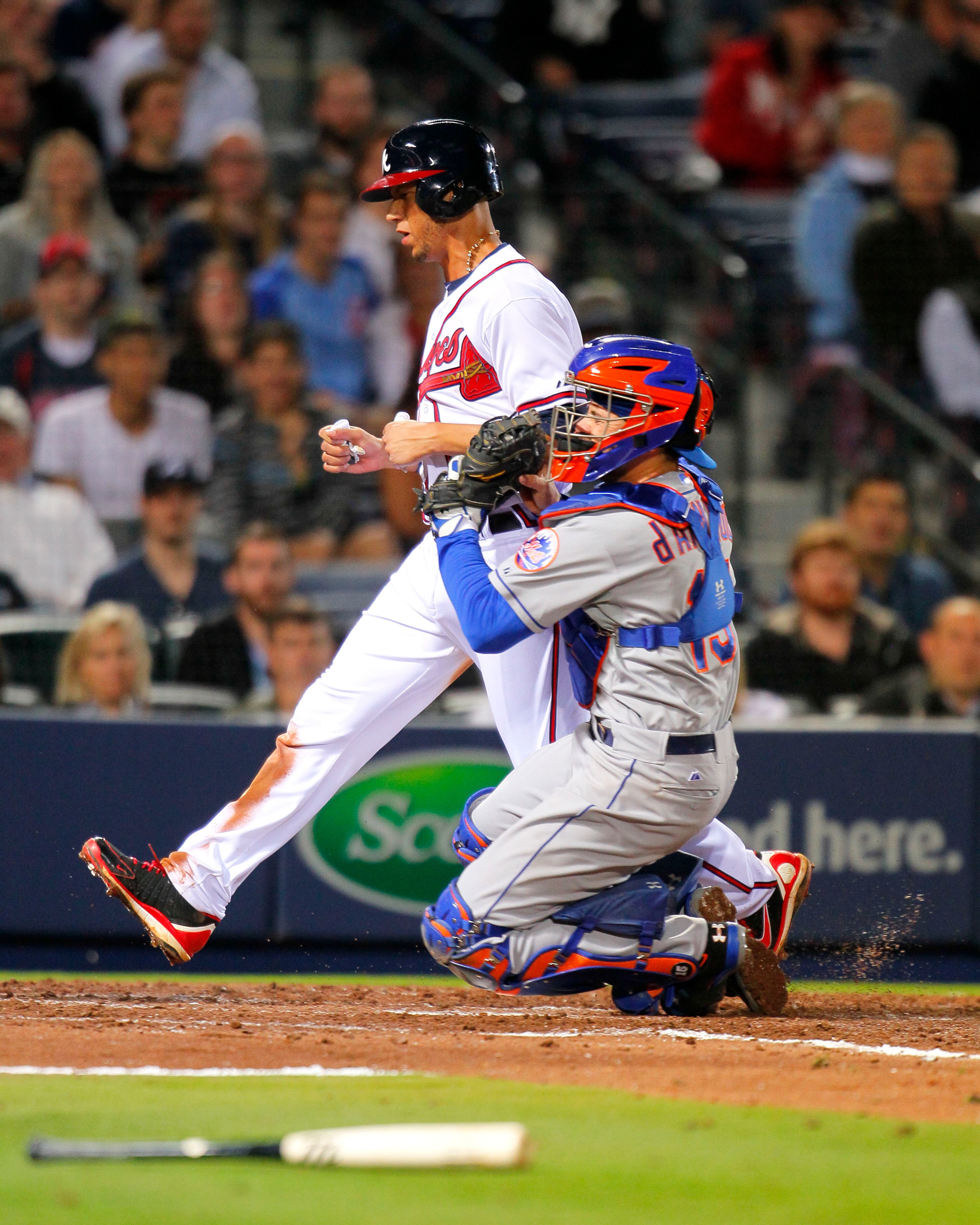 Atlanta Braves' Andrelton Simmons, top, is tagged out by New York Mets catcher Travis d'Arnaud at the plate in the fifth inning of a baseball game on Wednesday, April 9, 2014, in Atlanta. (AP Photo/Todd Kirkland)