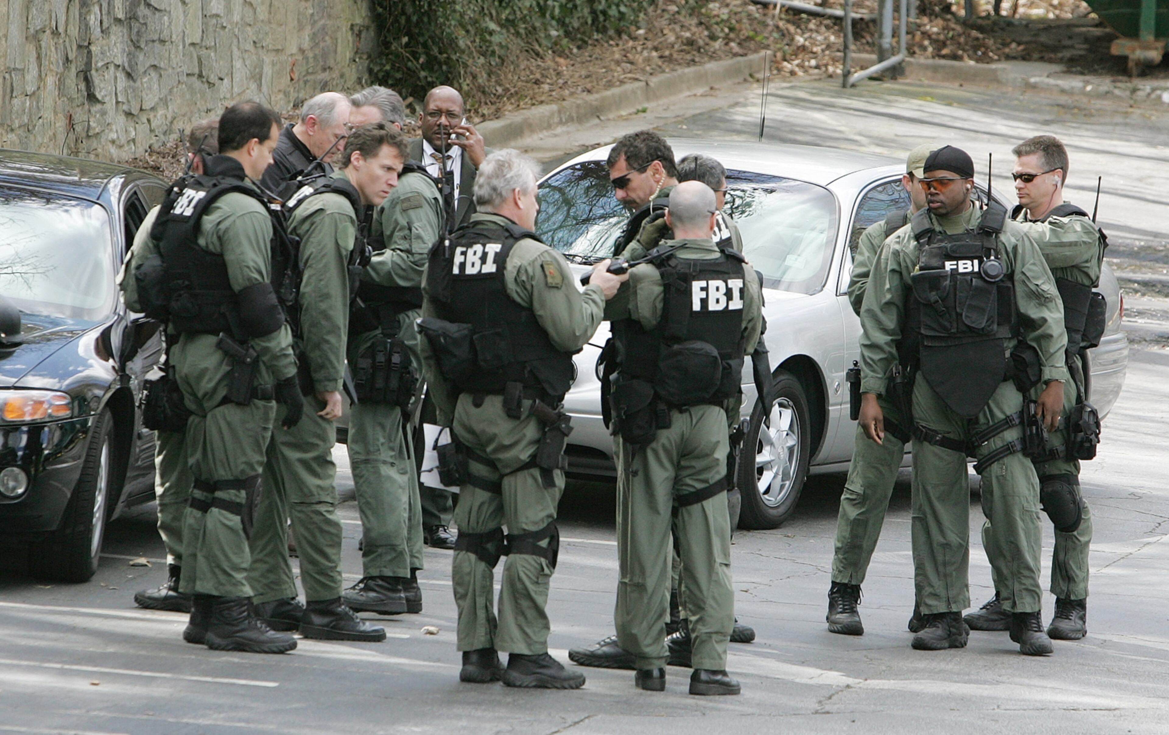 FBI personnel gear up in an Atlanta shopping center Friday, March 11, 2005, as they join the search for Brian Nichols, the suspect in the shooting of Superior Court Judge Rowland Barnes, his clerk and a Fulton County Deputy. Nichols was on trial for rape in the courthouse. (AP Photo/Ric Feld)