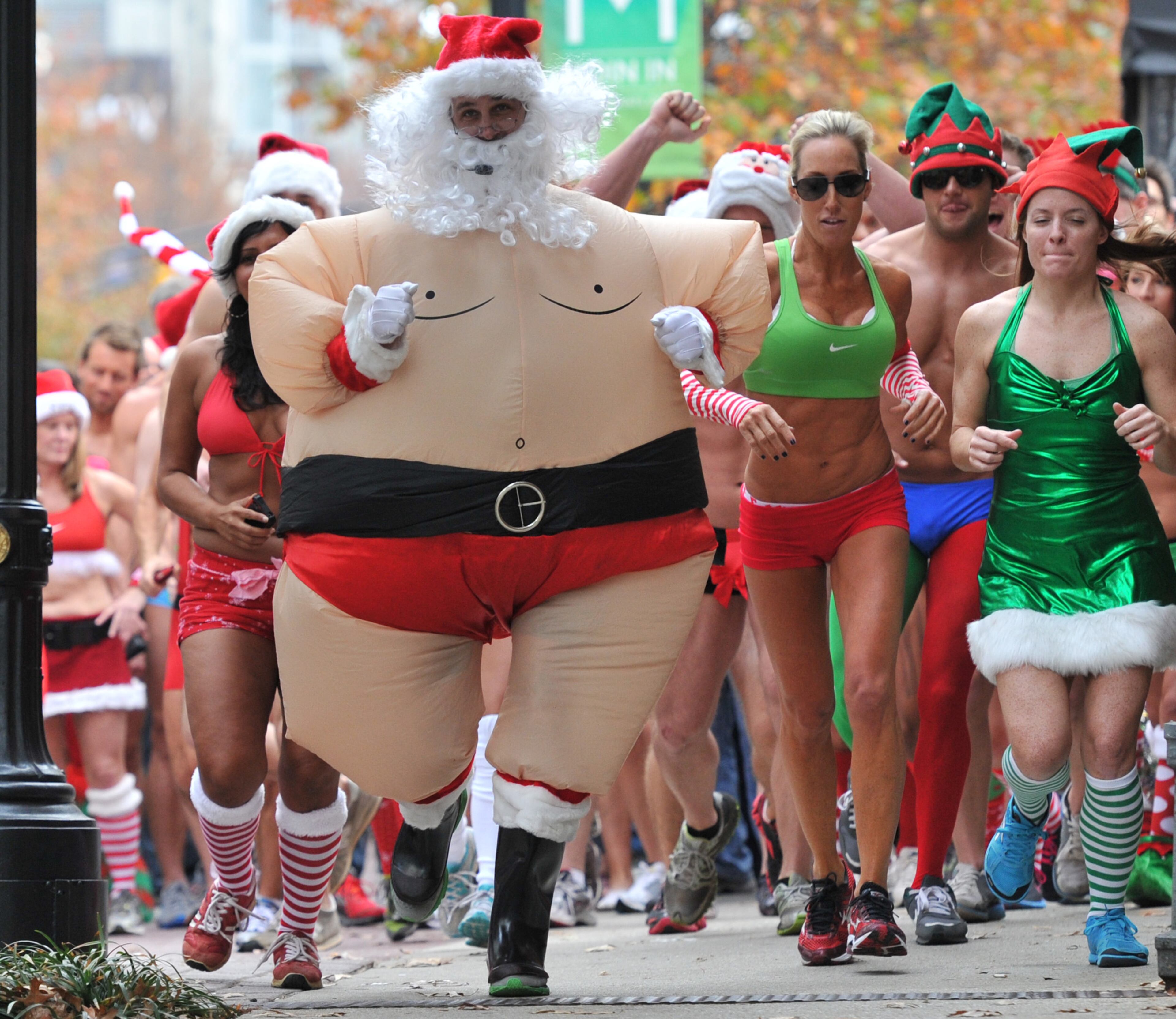 Approximately 300 runners cross the starting line at Hudson Grill Midtown on Peachtree Street during Atlanta Santa Speedo Run Saturday, Dec. 8, 2012.