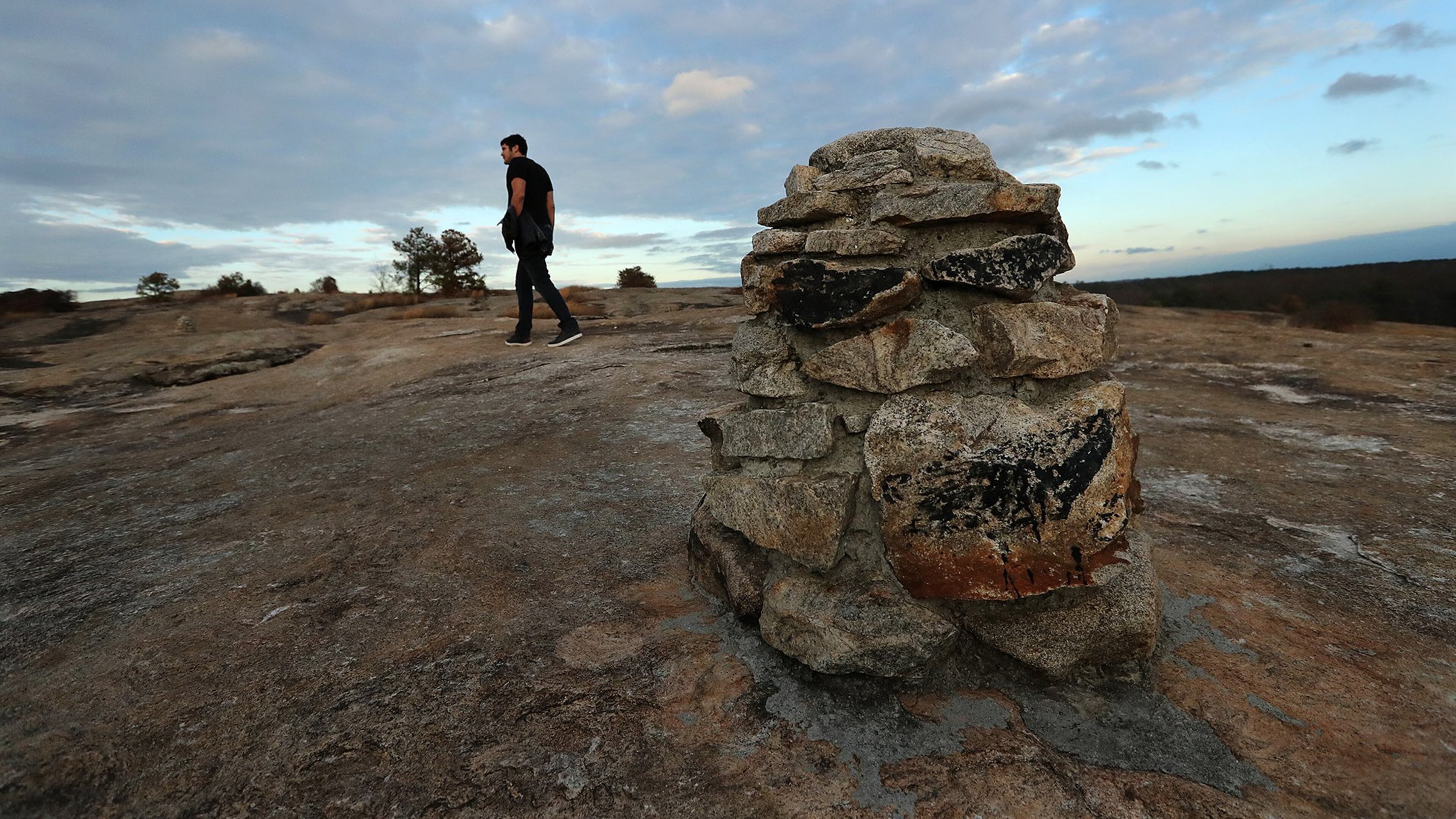 Preston Hamilton, Atlanta, follows stone path markers exploring a section near the summit of the Arabia Mountain Trail. Curtis Compton/ccompton@ajc.com