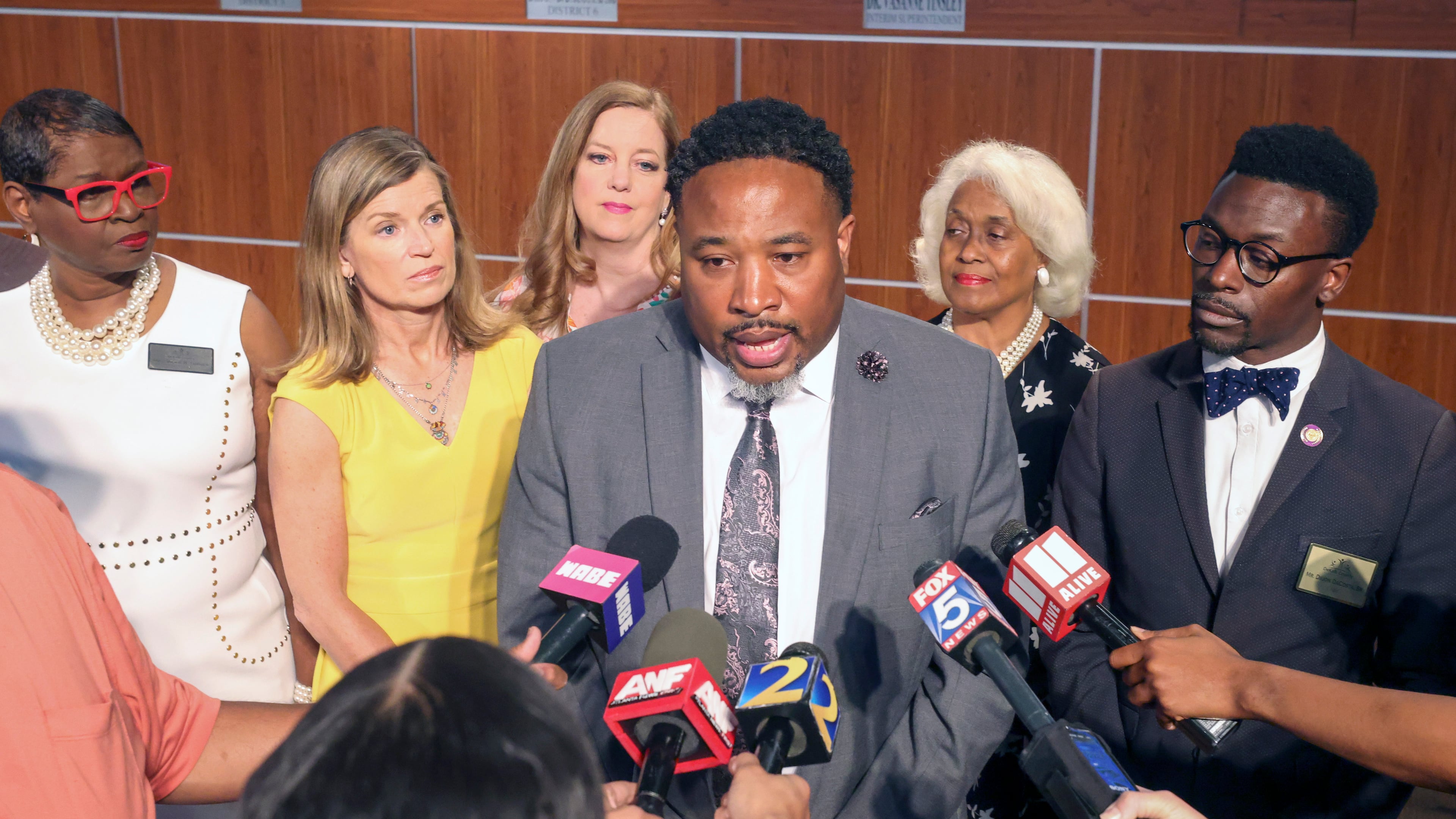 Devon Horton talks with members of the media after the DeKalb County Board of Education hired him for the superintendent position at the DeKalb County Administrative Center on April 19, 2023, in Stone Mountain, Ga. Behind Horton are five of the six board members who voted yes for him. (Jason Getz / AJC)