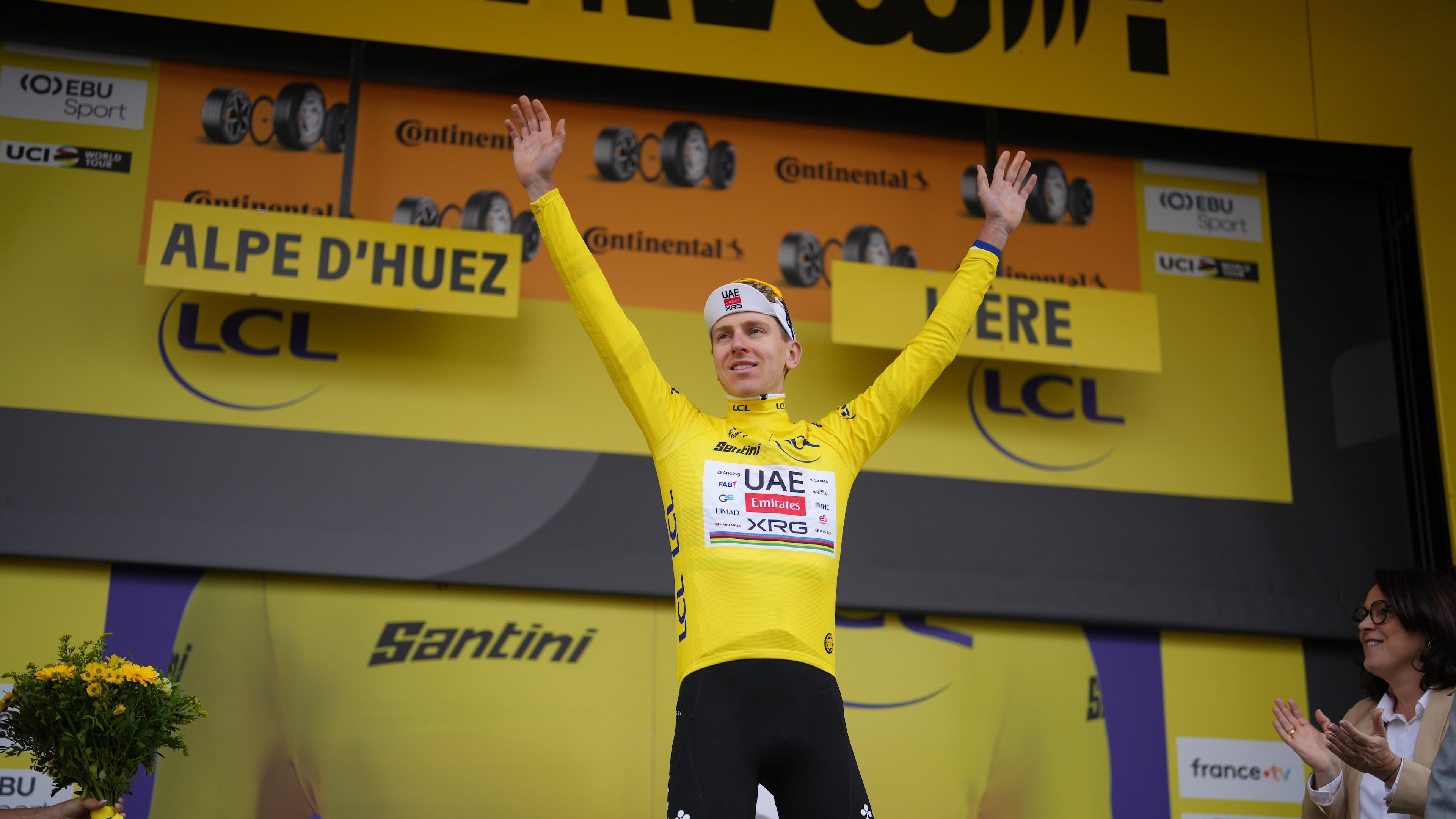 Slovenia's Tadej Pogacar, wearing the overall leader's yellow jersey, celebrates on the podium after the twentieth stage of the Tour de France cycling race with start in Le Bourg d'Oisans and finish in Alpe d'huez, France, Saturday, July 25, 2026. (AP Photo/Thibault Camus)