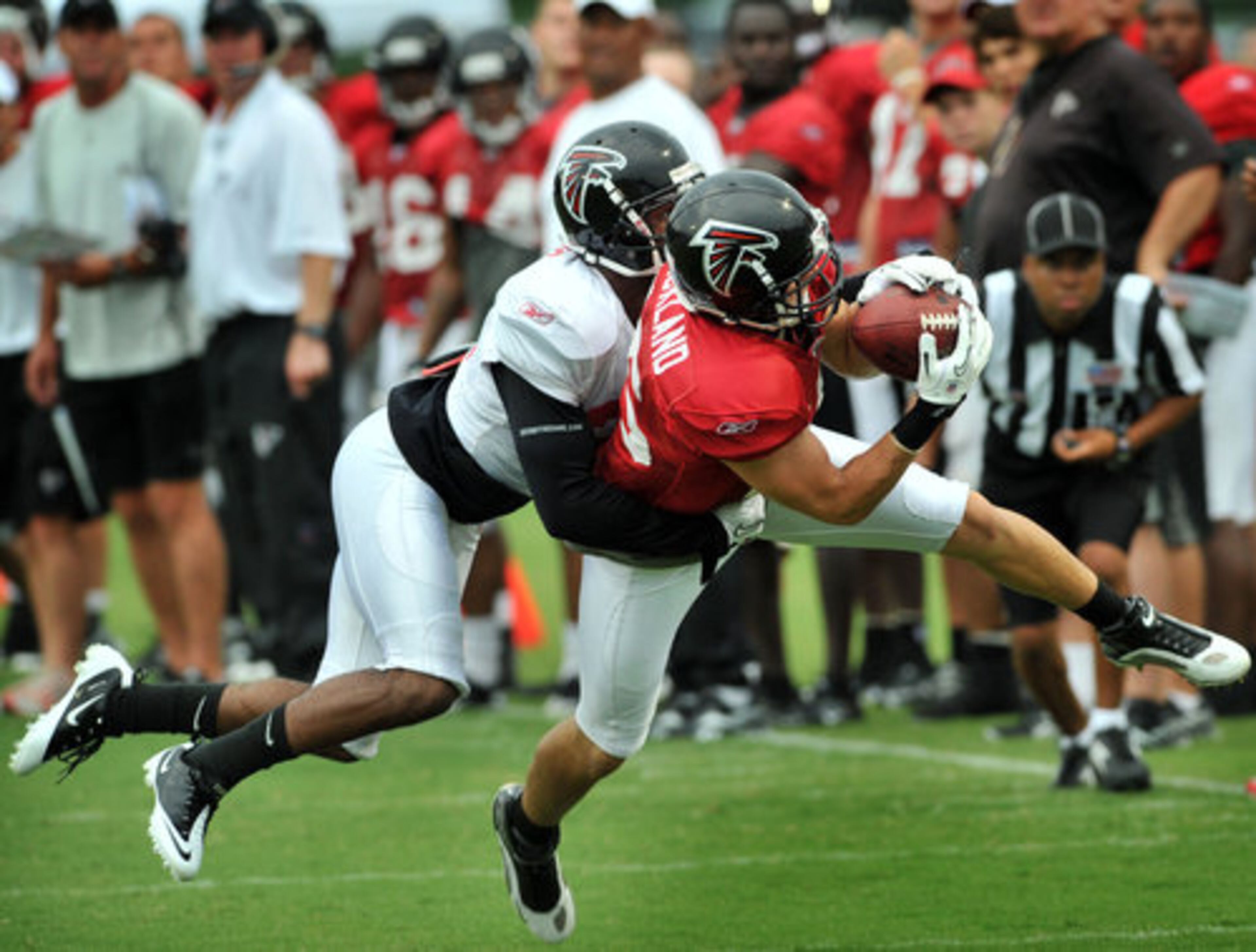 Atlanta Falcons Andy Strickland (15, right) makes a catch as Christopher Owens (21) tries to tackle during the Friday Night Lights at North Gwinnett High School in Suwanee.