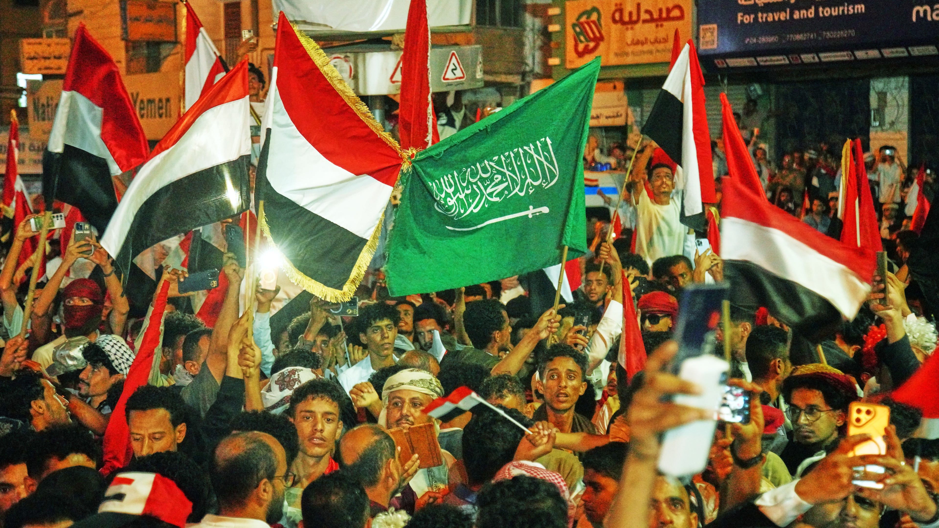 Yemenis wave national and Saudi flags as they celebrate the 64th anniversary of the September 26 Revolution in Taiz, Yemen, Friday, Sept. 25, 2026. (AP Photo/Abdulnasser Alseddik)