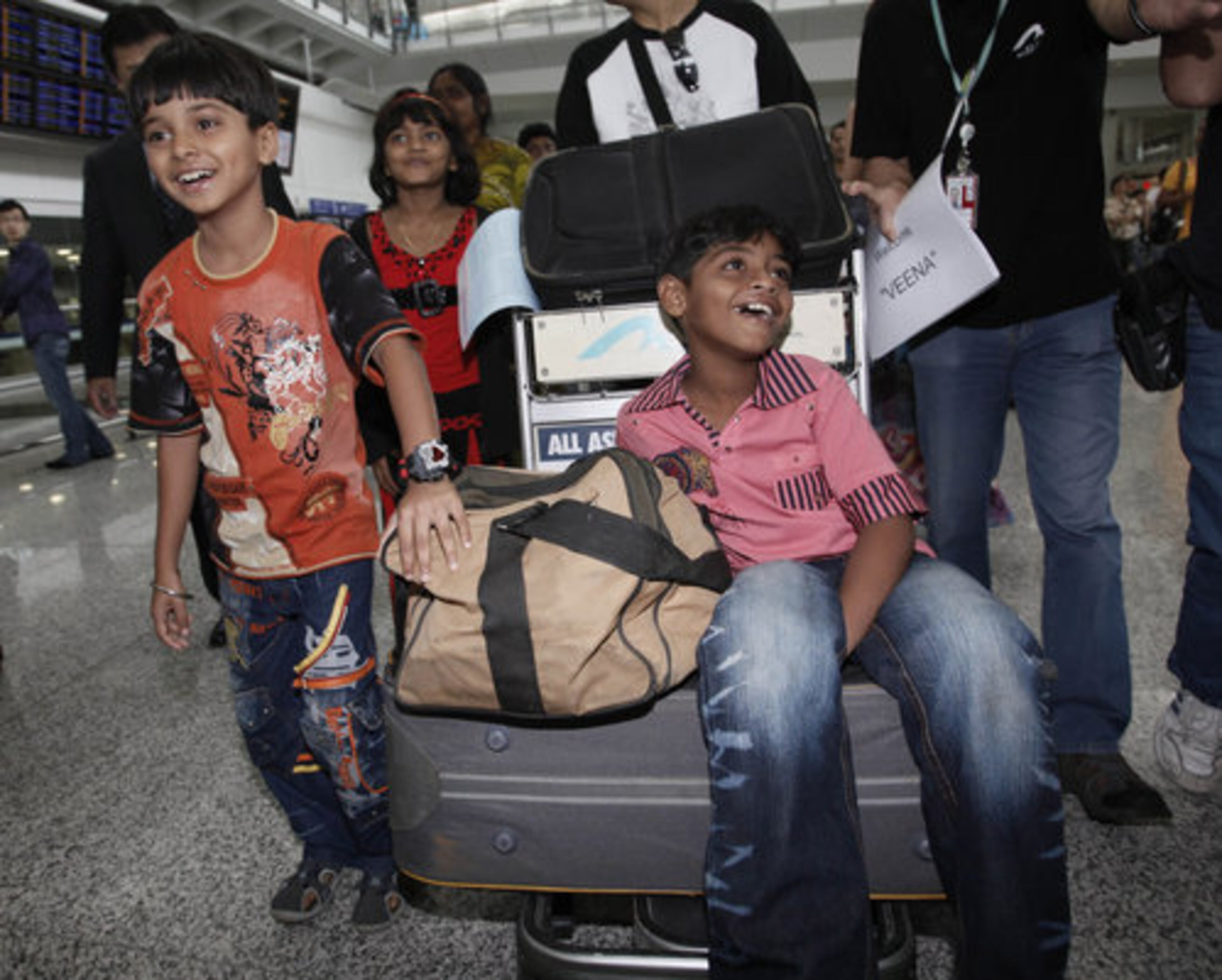 The child actors in the film "Slumdog Millionaire" went back to India as media darlings. But they live strange, paradoxical lives: glamorous events one week, poverty the next. Here Ayush Mahesh Khedekar, Rubina Ali (in red) and Azharuddin Mohammed Ismail arrive in Hong Kong, where they will attend a charity show.